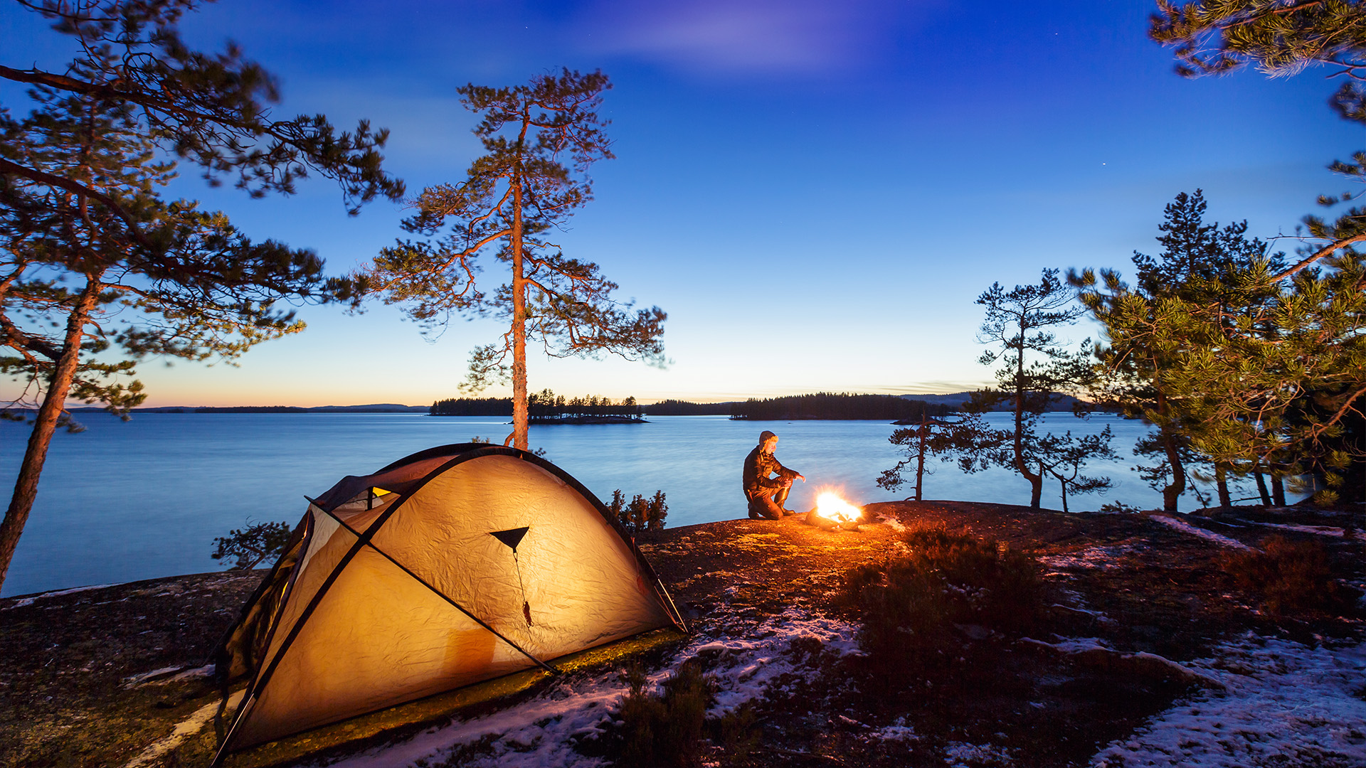 Camper and bonfire in Finnish lake landscape