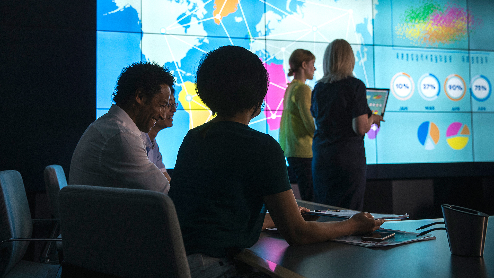 Workers in office in front of big data-screen