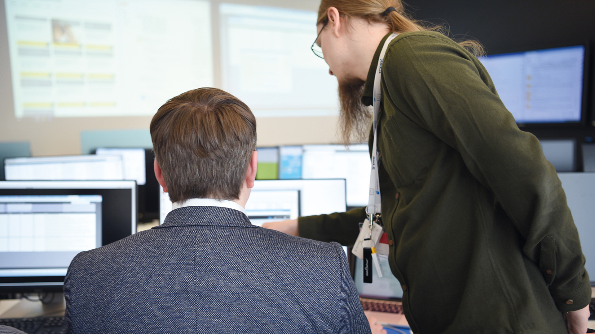 Two cybersecurity specialists looking to the screen.