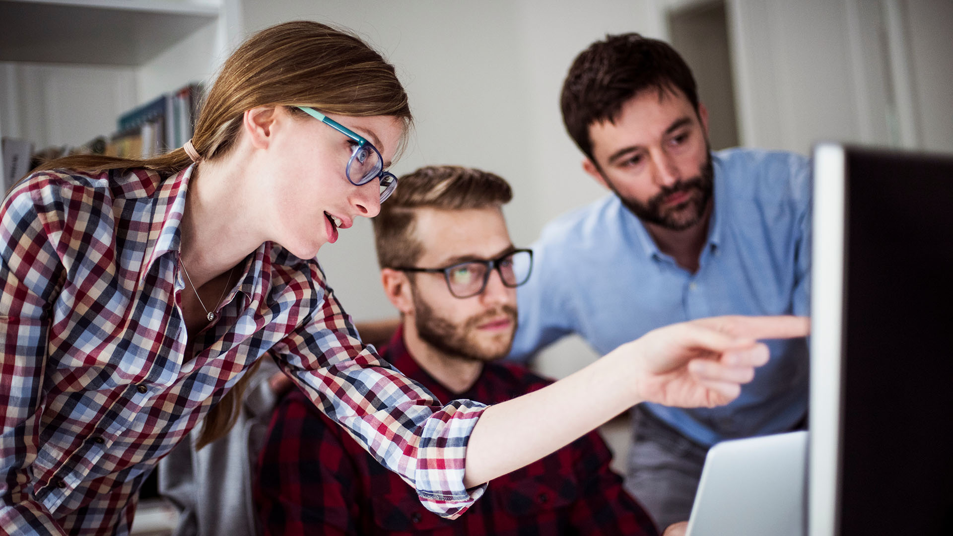 Kolme opiskelijaa tietokoneen näytön edessä
