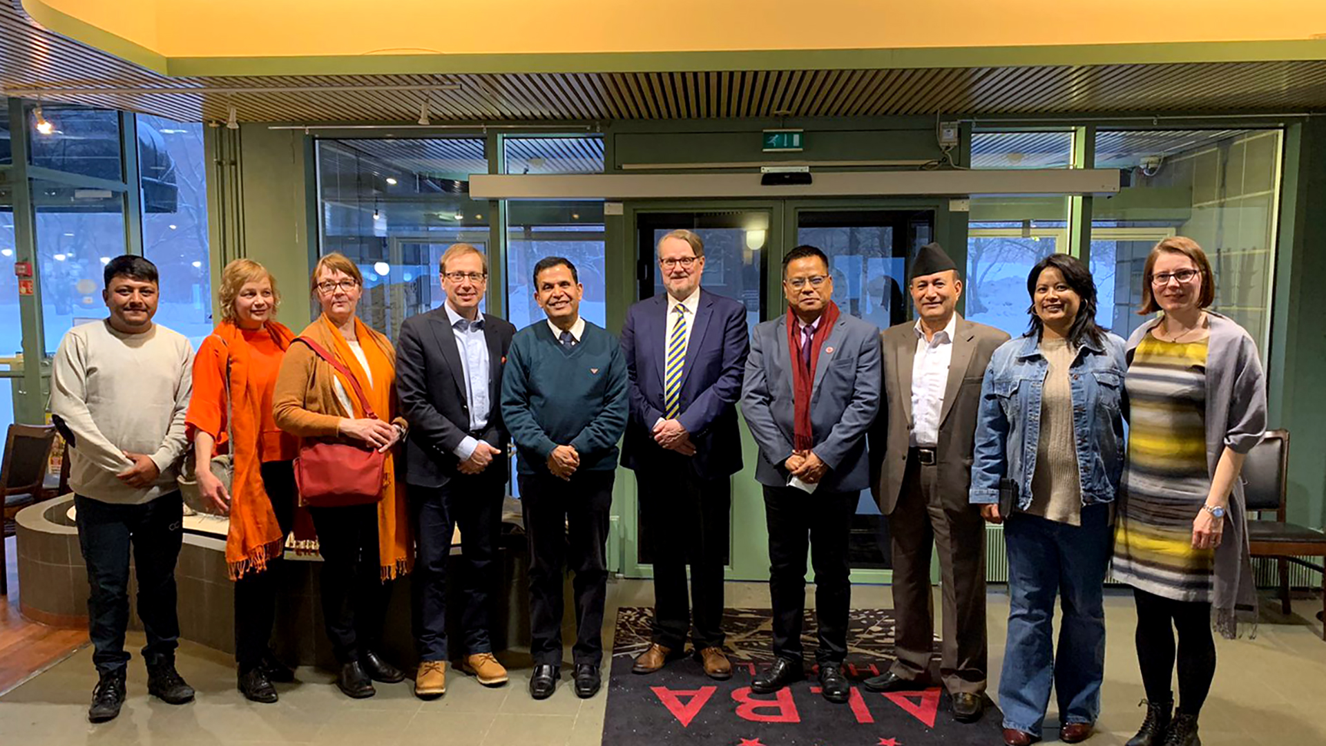 Ten people, benchmarking visitors and Jamk personnel, standing in line in hotel Alba's lobby