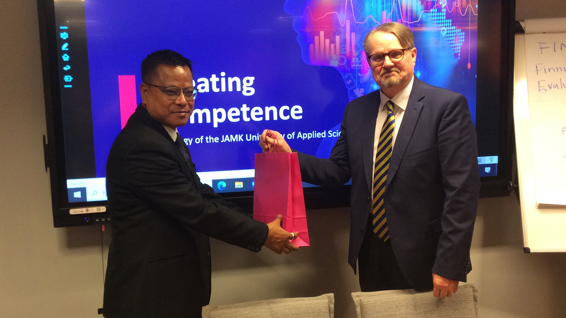 professor Bim Prasad Shrestha with Jamk's rector receiving a gift bag