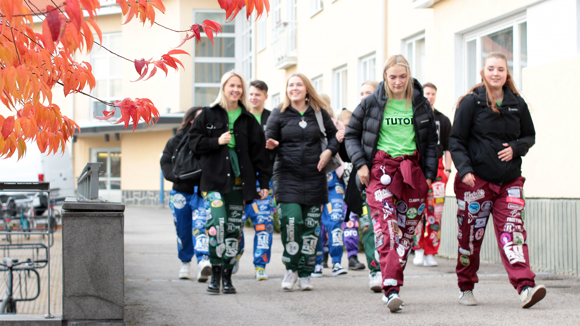 Ryhmä tutor-opiskelijoita kävelee Jyväskylän ammattikorkeakoulun rakennuksen edustalla.