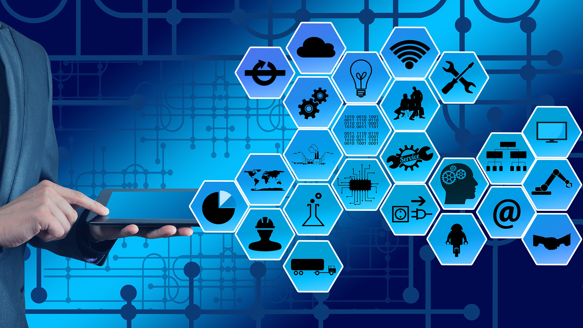 Miehen käsi tablettitietokoneella. Kuvan päällä teollisuuden ikoneita.