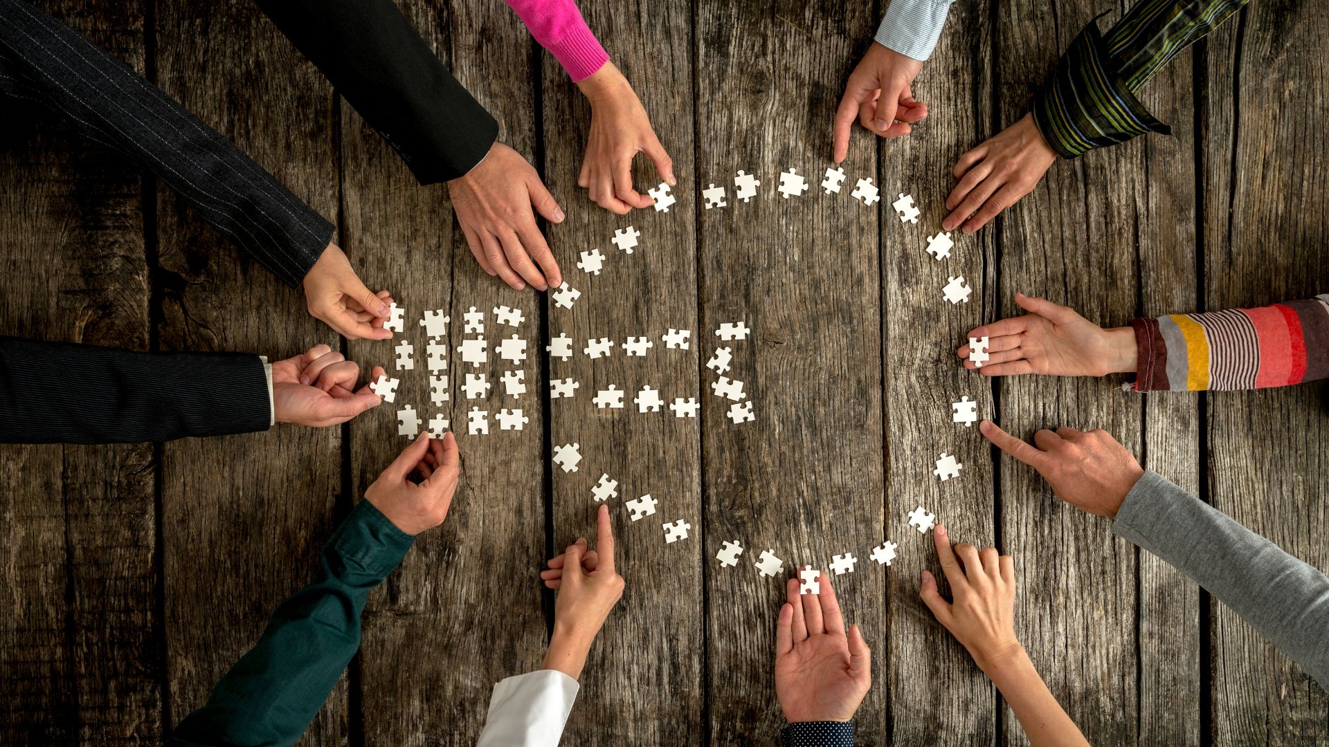 Virtual Leaders mukaan projektiin Virtual Leaders ihmisten käsiä pöydän ympärillä