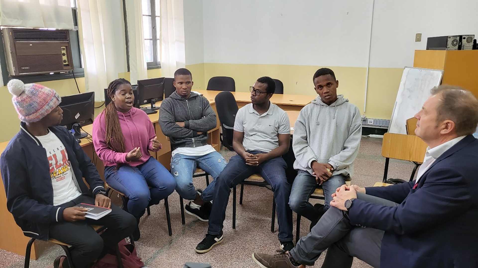 Mozambican students sitting next to each other and speaking.