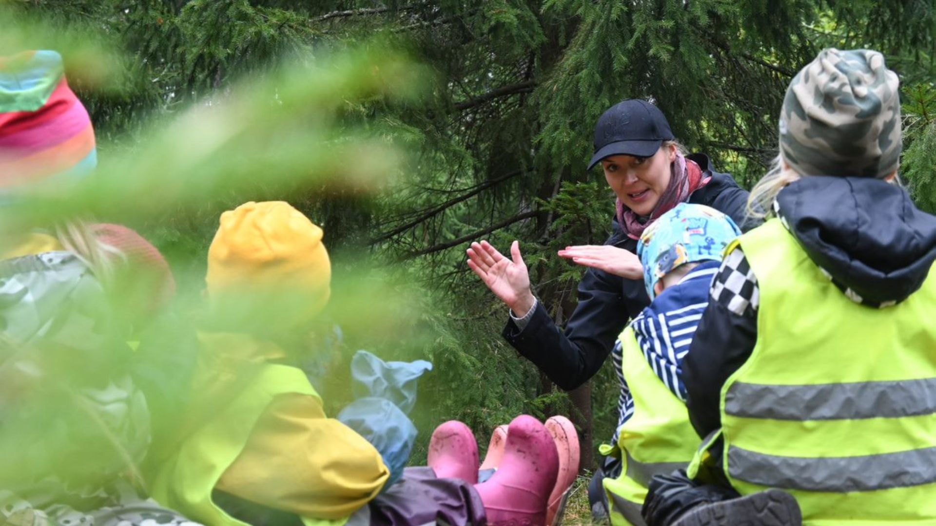 nainen puhuu lapsille metsässä