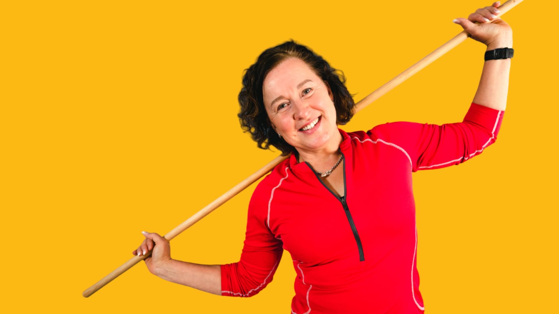 Henkilö pitelee jumppakeppiä hartioillaan.