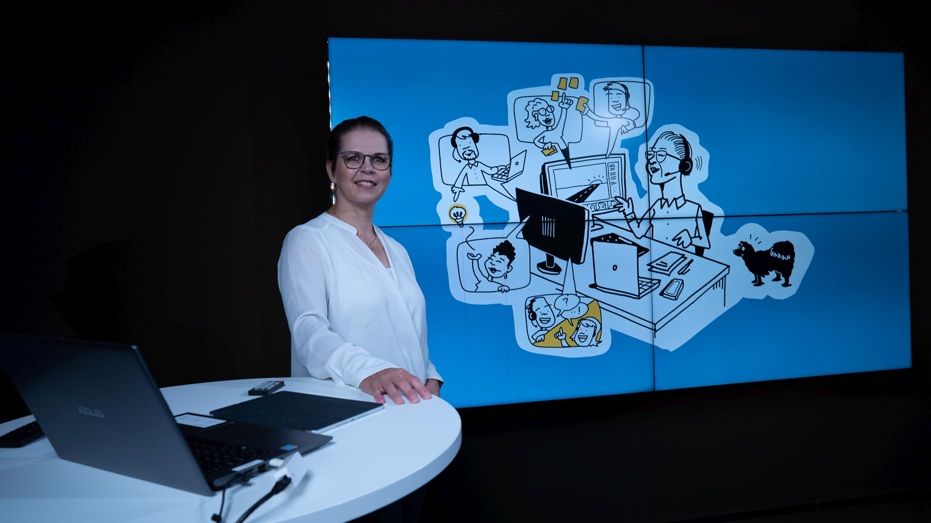 Alumnin ääni -webinaarivieras Tiina Lakkaneva seisoo piirretyn kuvan edessä