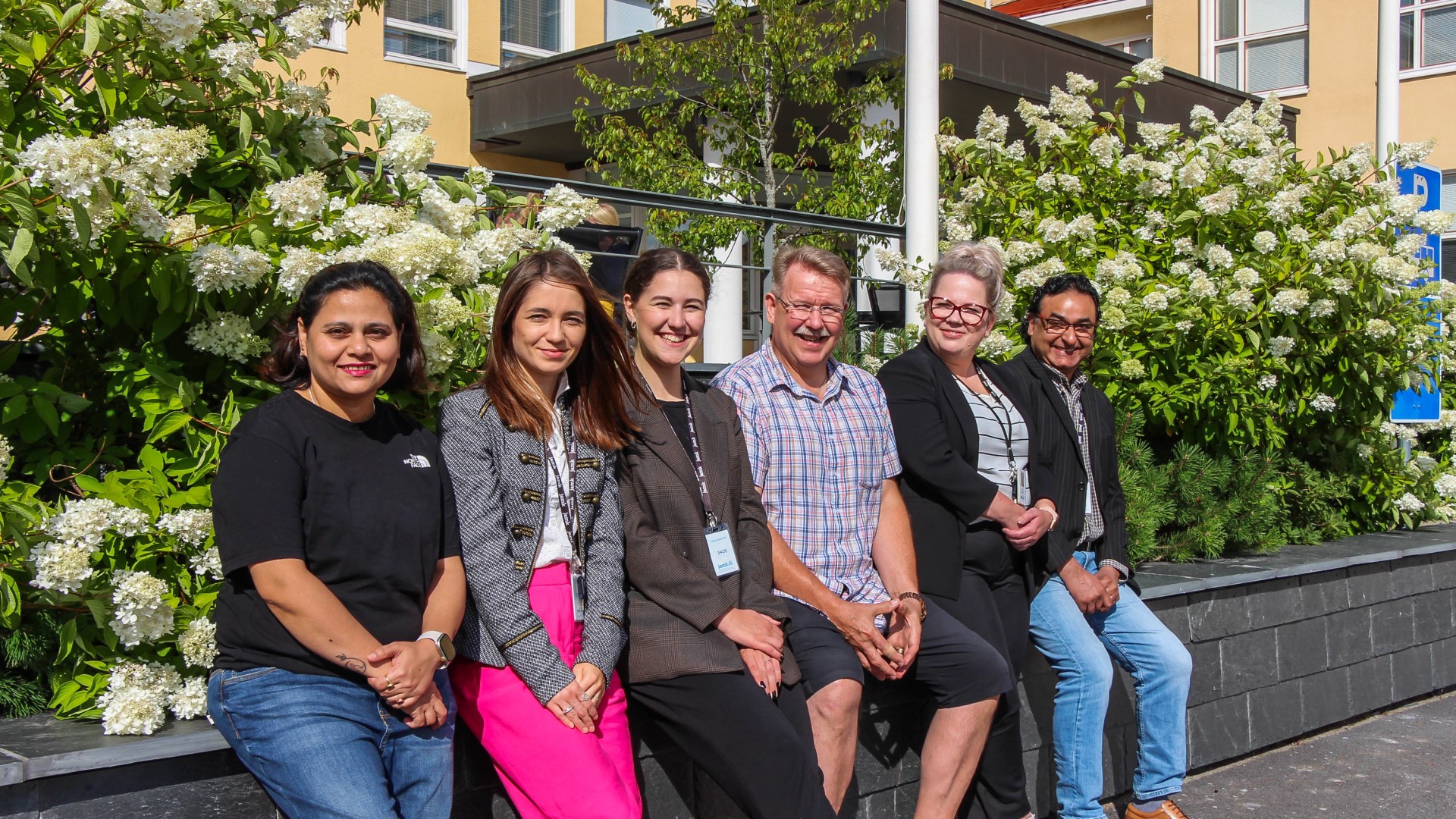 Jamk's international six-member business team smiling in front of the camera