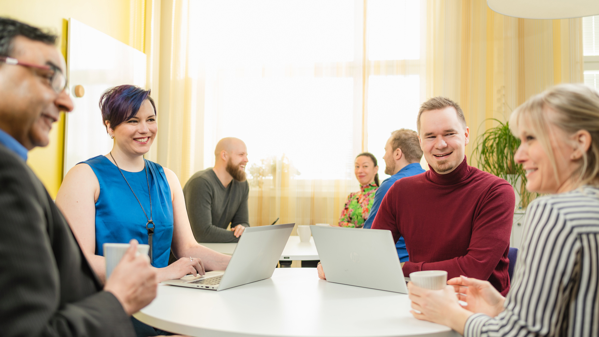 Adults co-working with laptops.