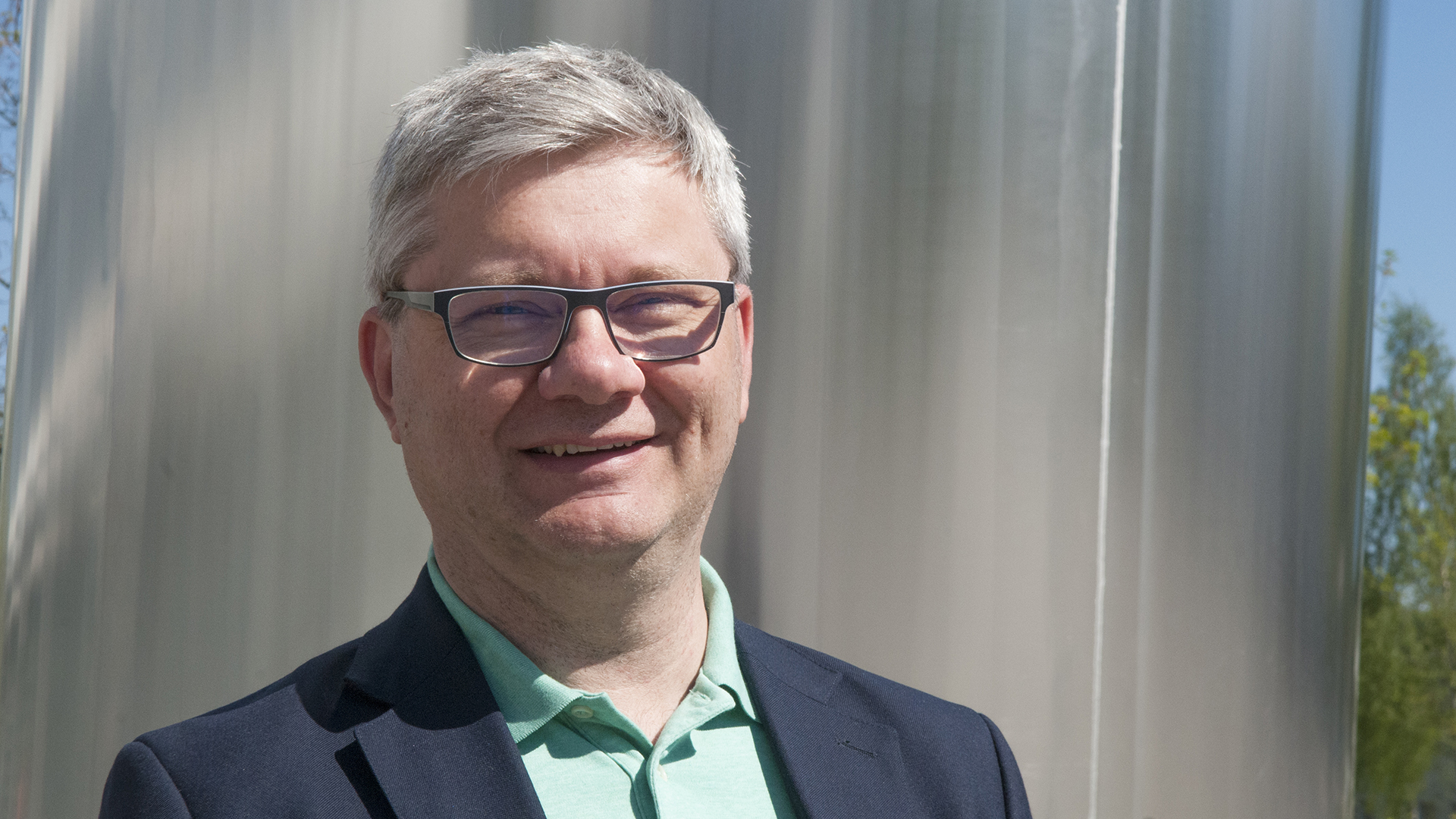 Mies hymyilee kameralle