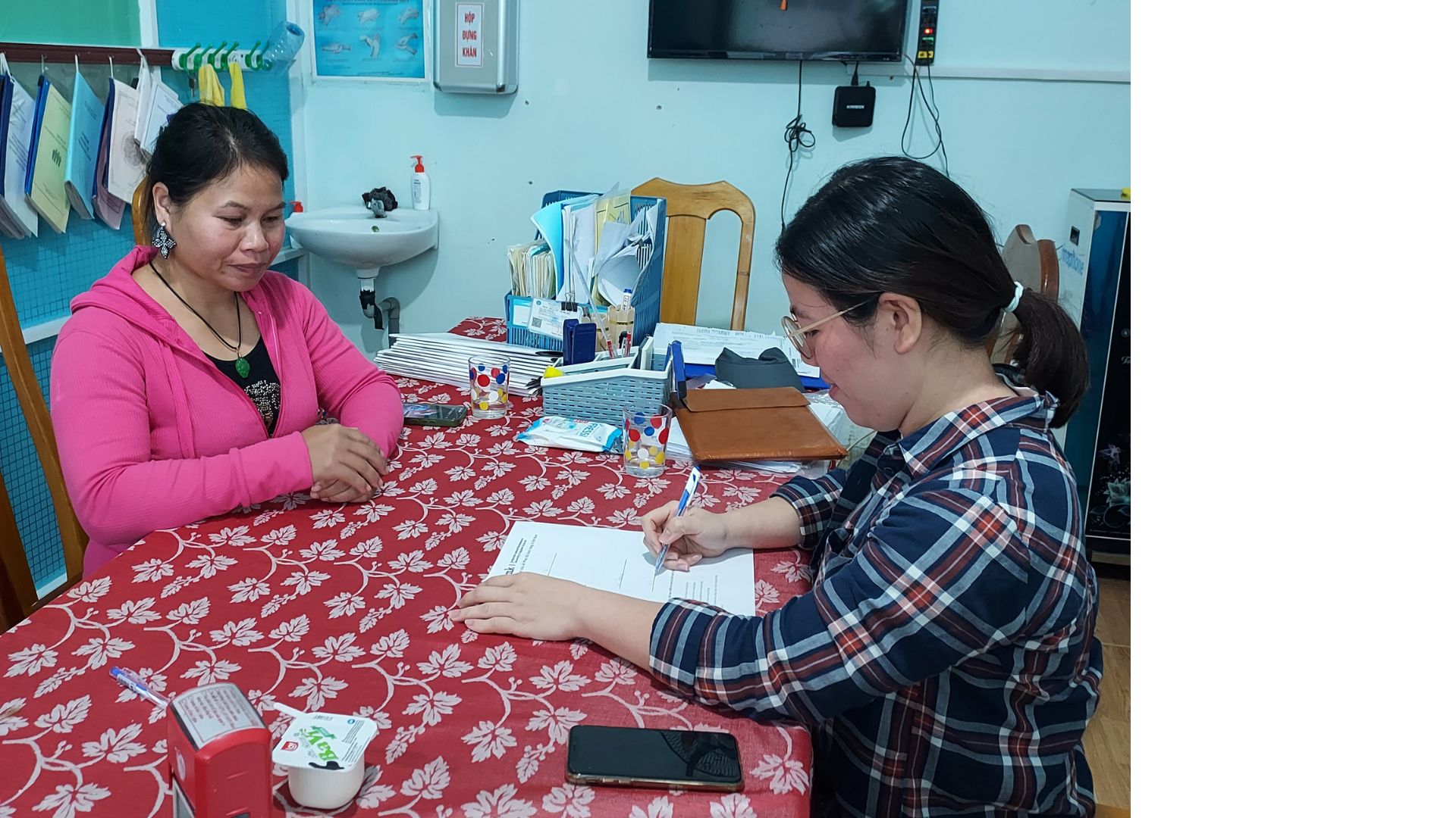 A female client and a health professional filling in a form