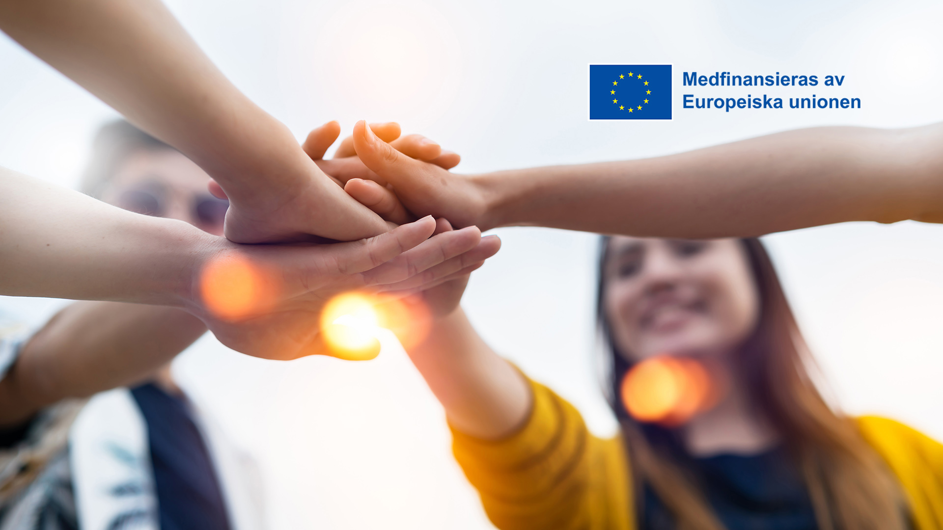 Unga leende vuxna med händer tillsammans, EU logo