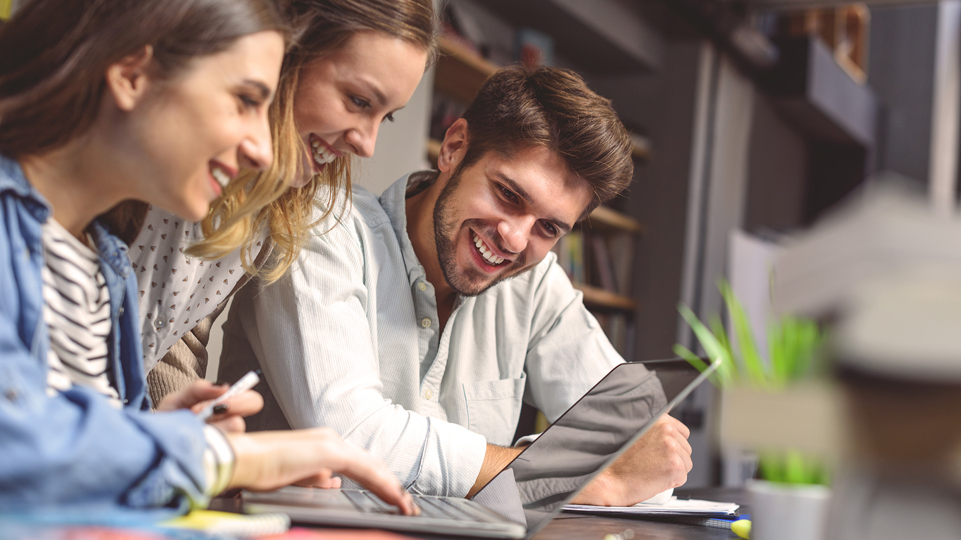 Opiskelijoita työskentelemässä yhdessä pöydän ääressä