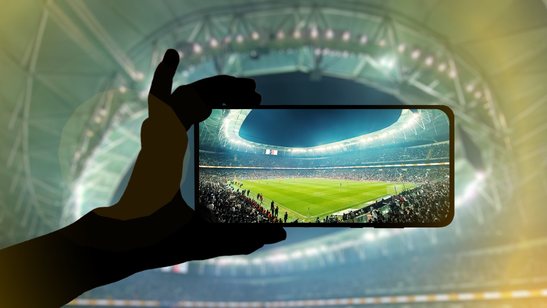 Fan hand with mobile phone photographing football game.