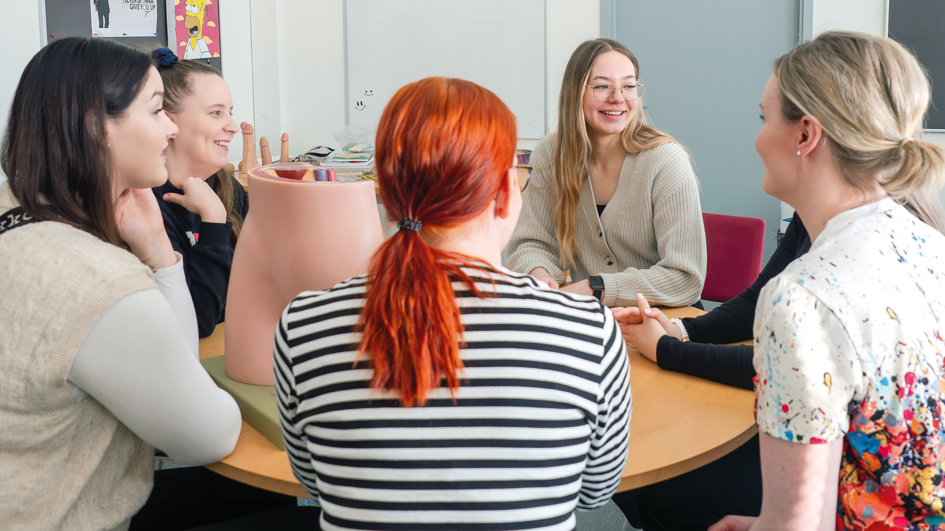 Opiskelijat keskustelemassa seksuaalikasvatuksesta pöydän ääressä