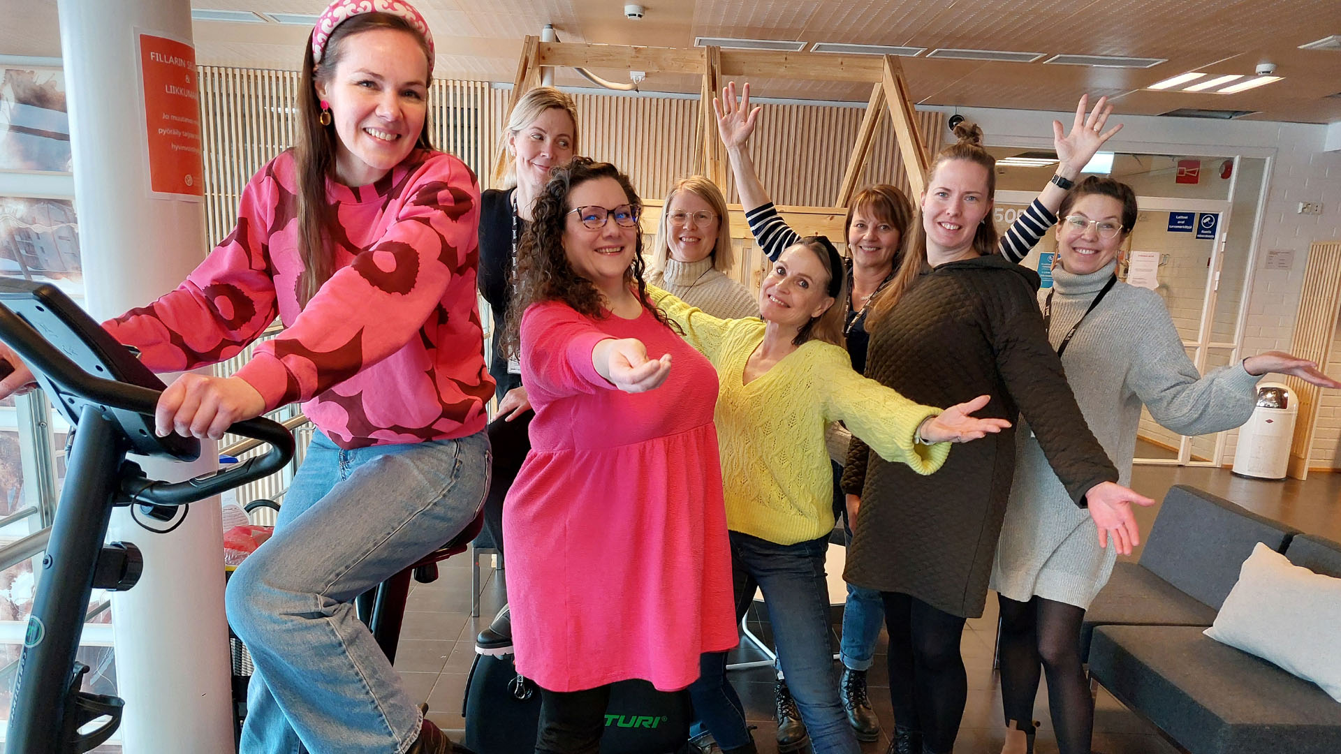 Henkilö polkee kuntopyörää ja iloisia henkilöitä venytysasennoissa.