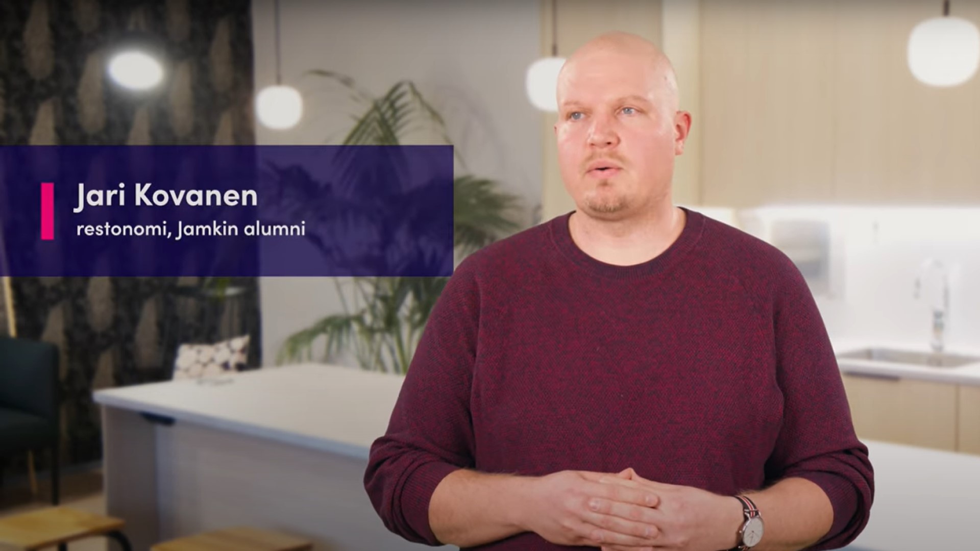 Mies puhuu kameralle taustallaan keittiö.