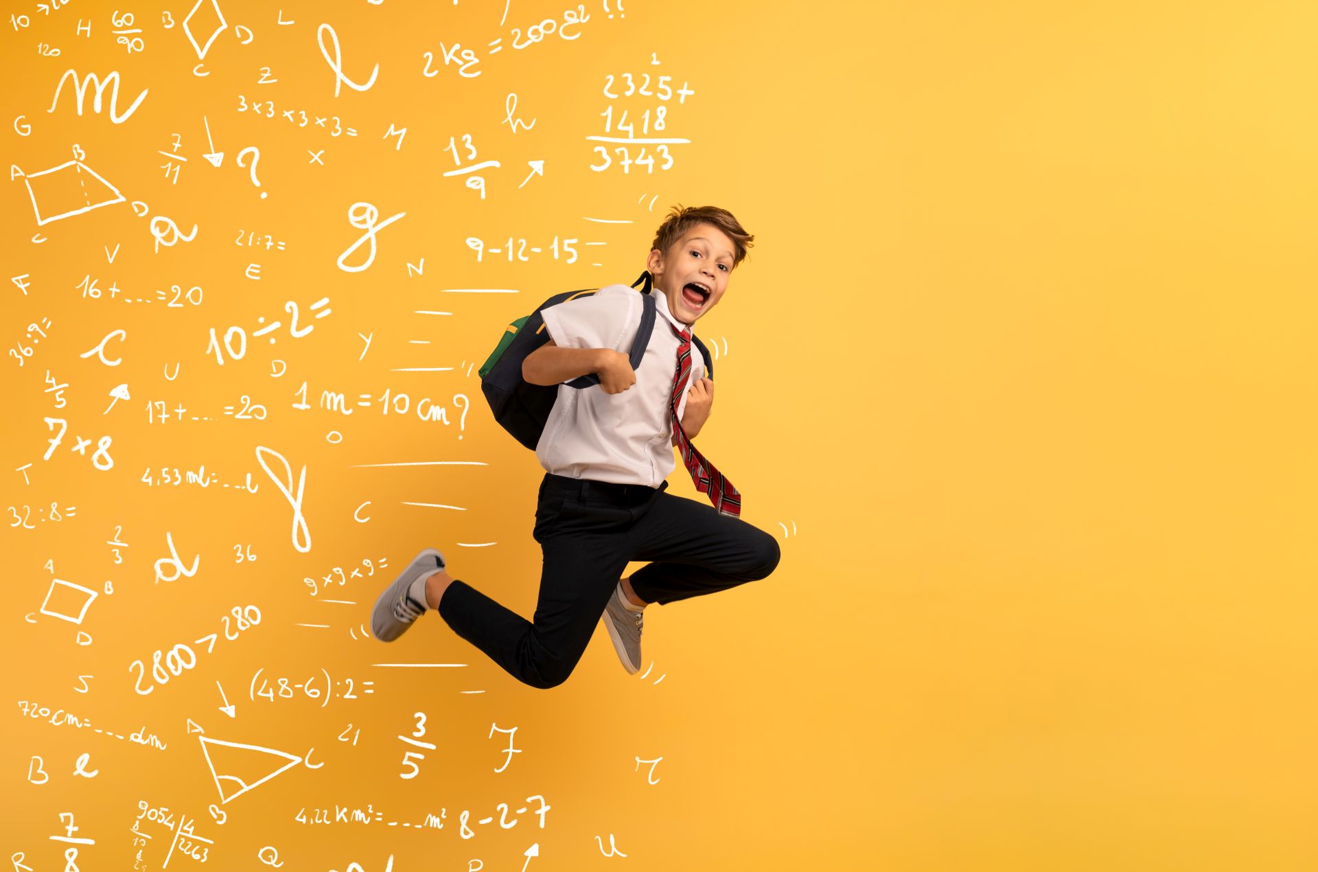 Lapsi hyppää seinän edessä. Seinässä on numeroita ja matemaattisia lukuja.