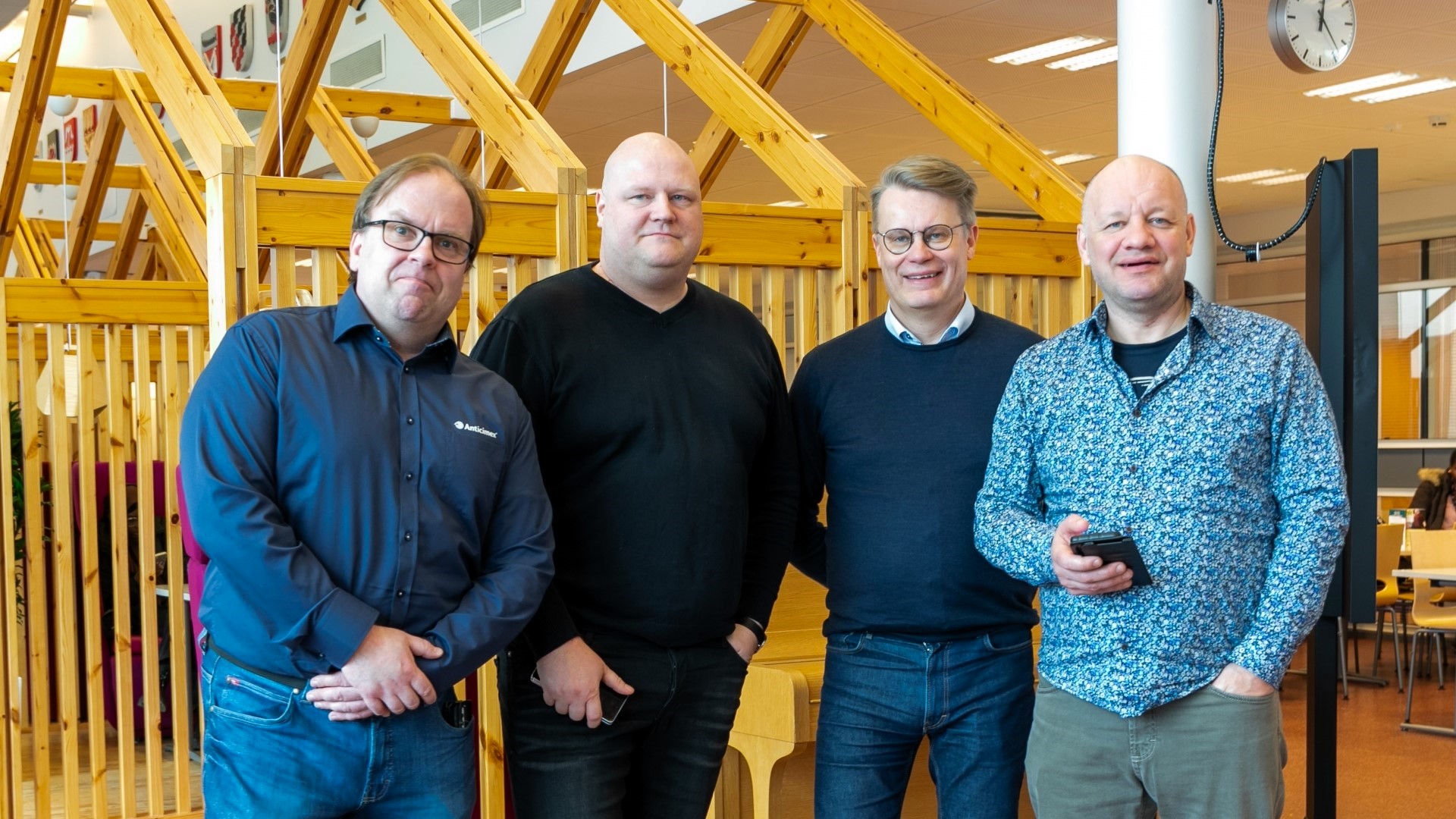 Neljä Jamkin alumnia reisoo jamkin ruokalassa ja katsoo kameraan hymyillen