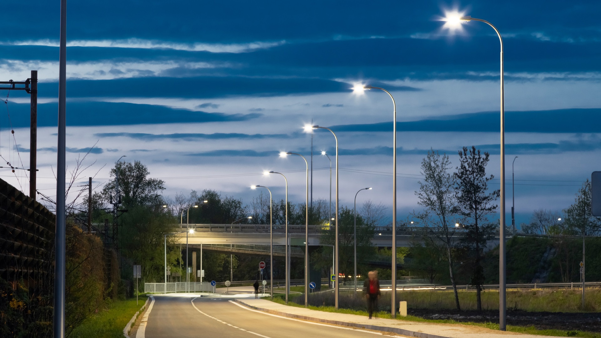 Kuvassa katuvaloilla valaistu tie iltahämärässä