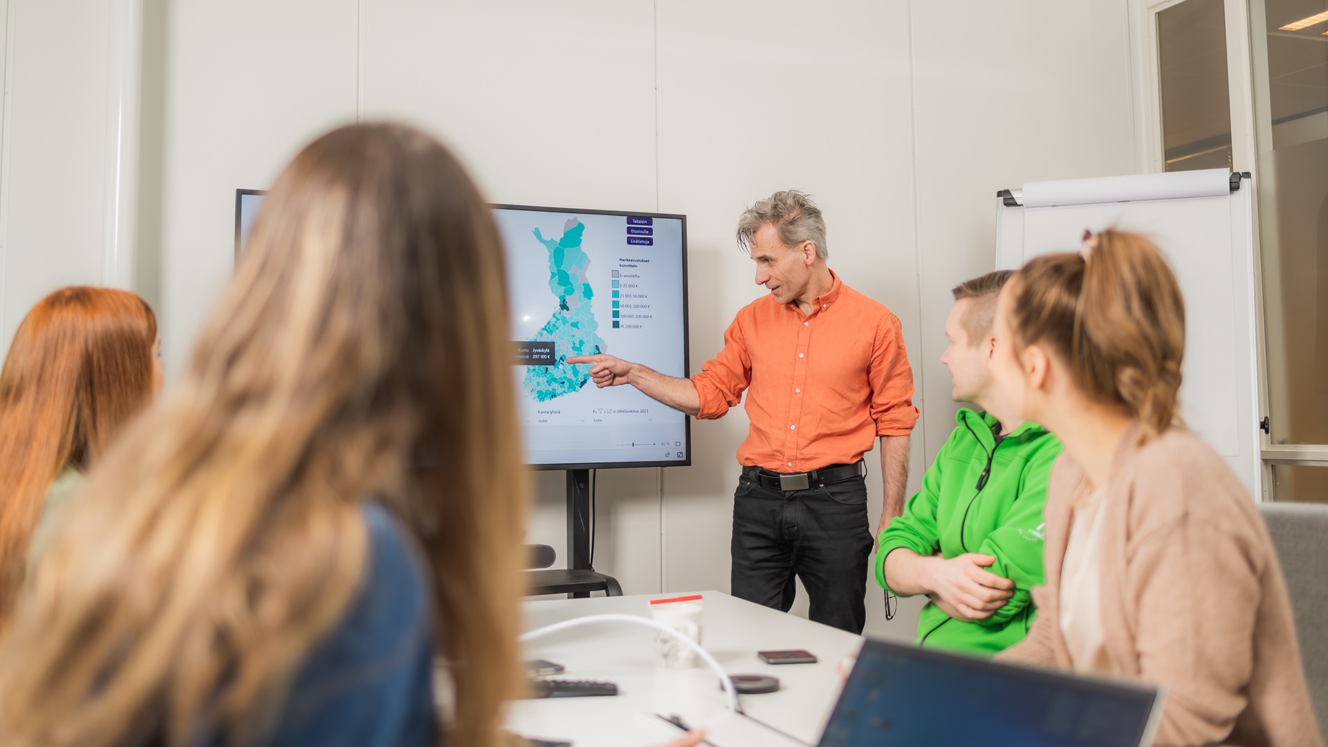 Kuvassa opiskelijoita ja toimeksiantaja