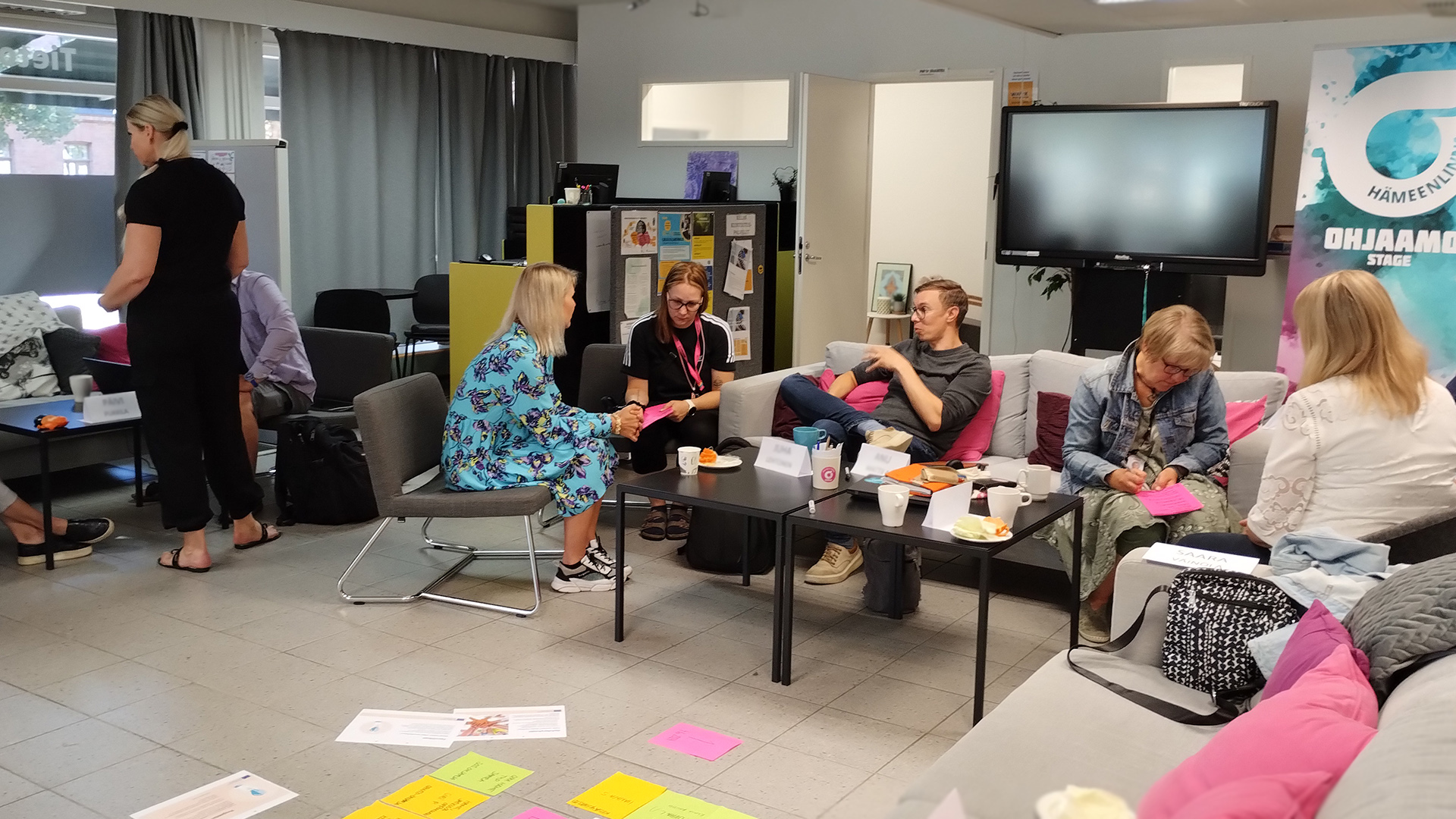 En grupp vuxna arbetar sittande och stående på soffor i Navigatorn.