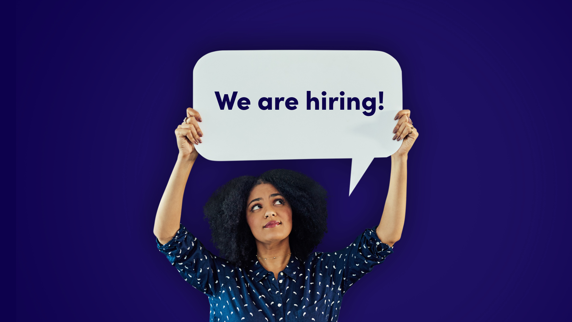 Tumma nainen ja kyltti "We are hiring"
