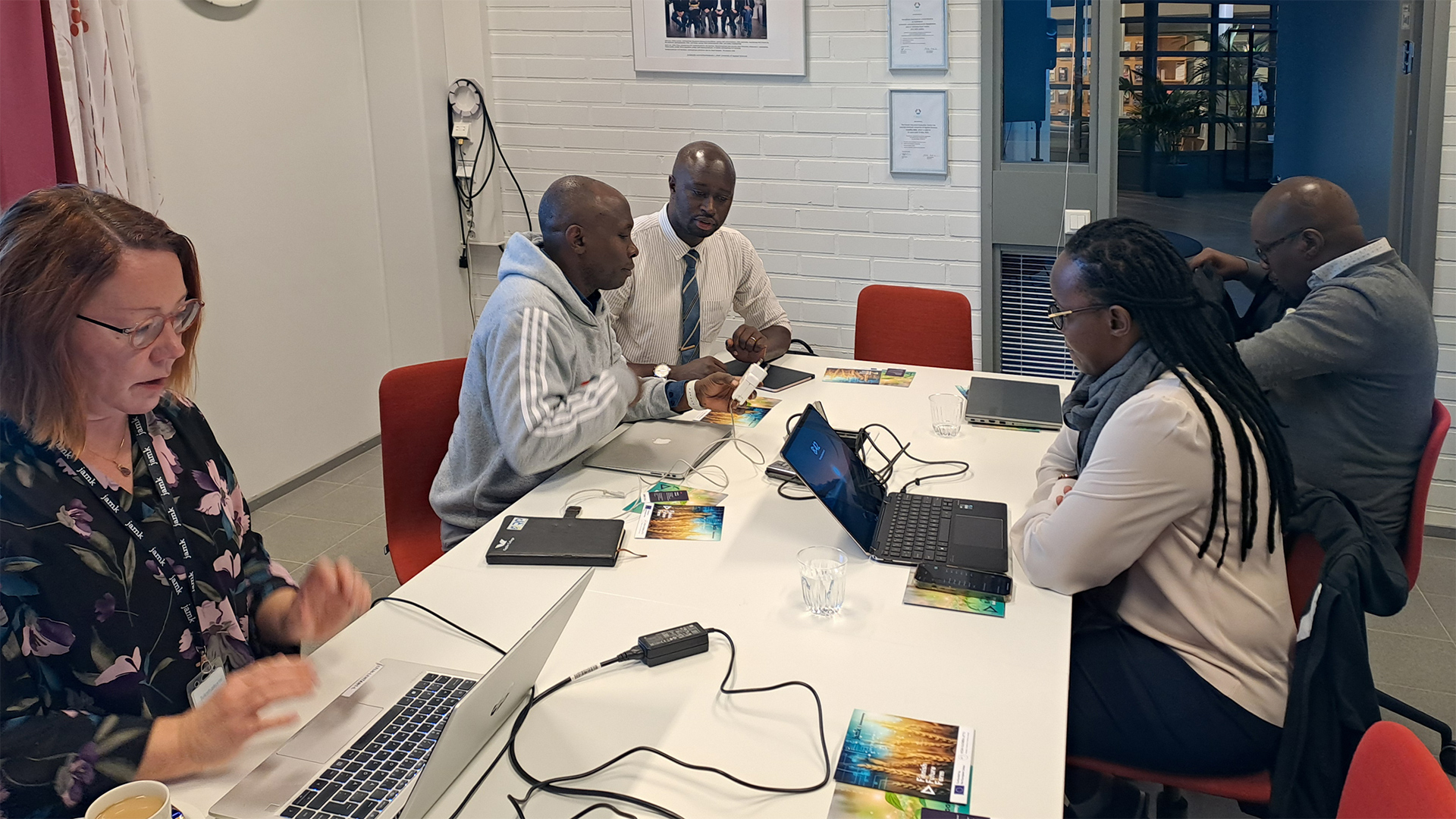 Four people discussing by a table at Jamk