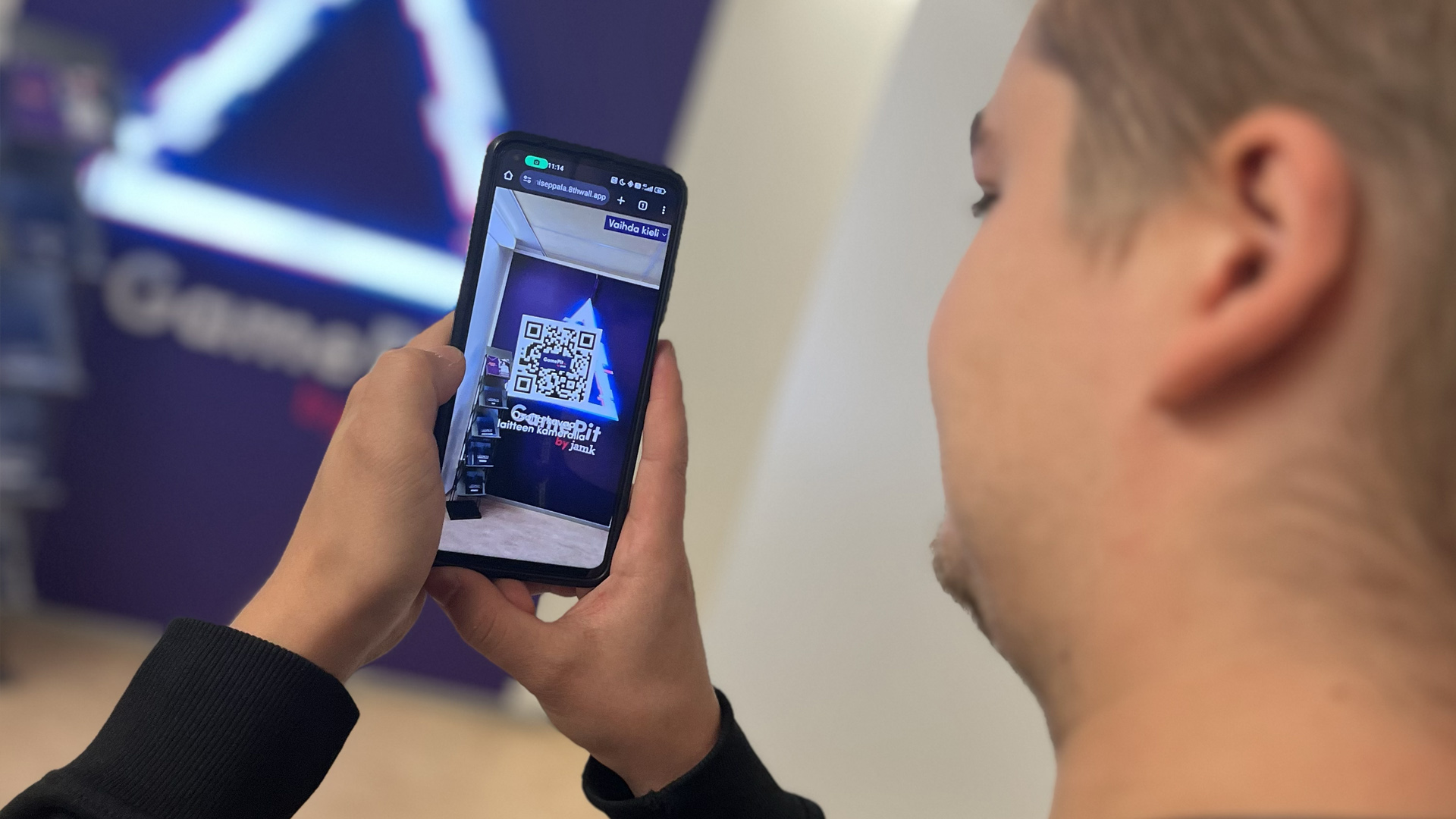 Mies katsoo kännykän ruudulta hologrammiesittelyä