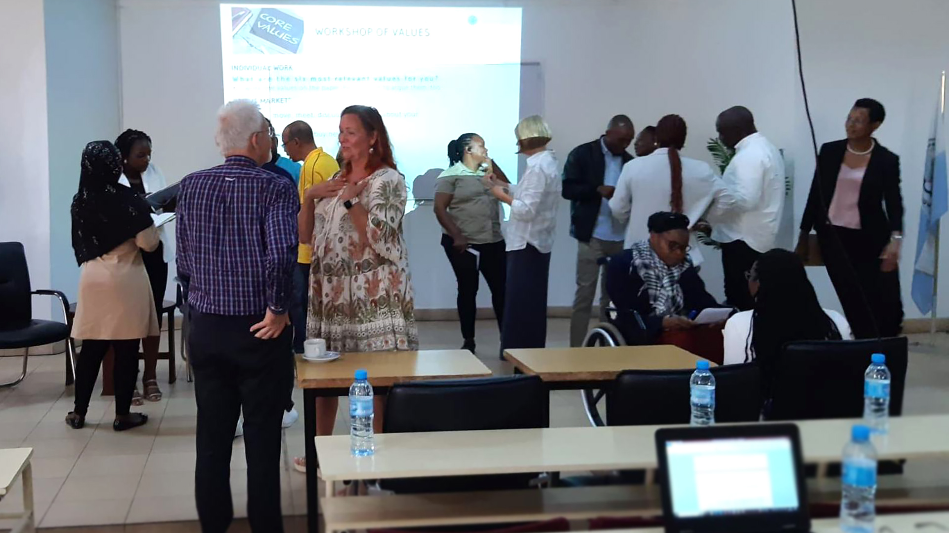 Group of adults standing and discussing in a classroom
