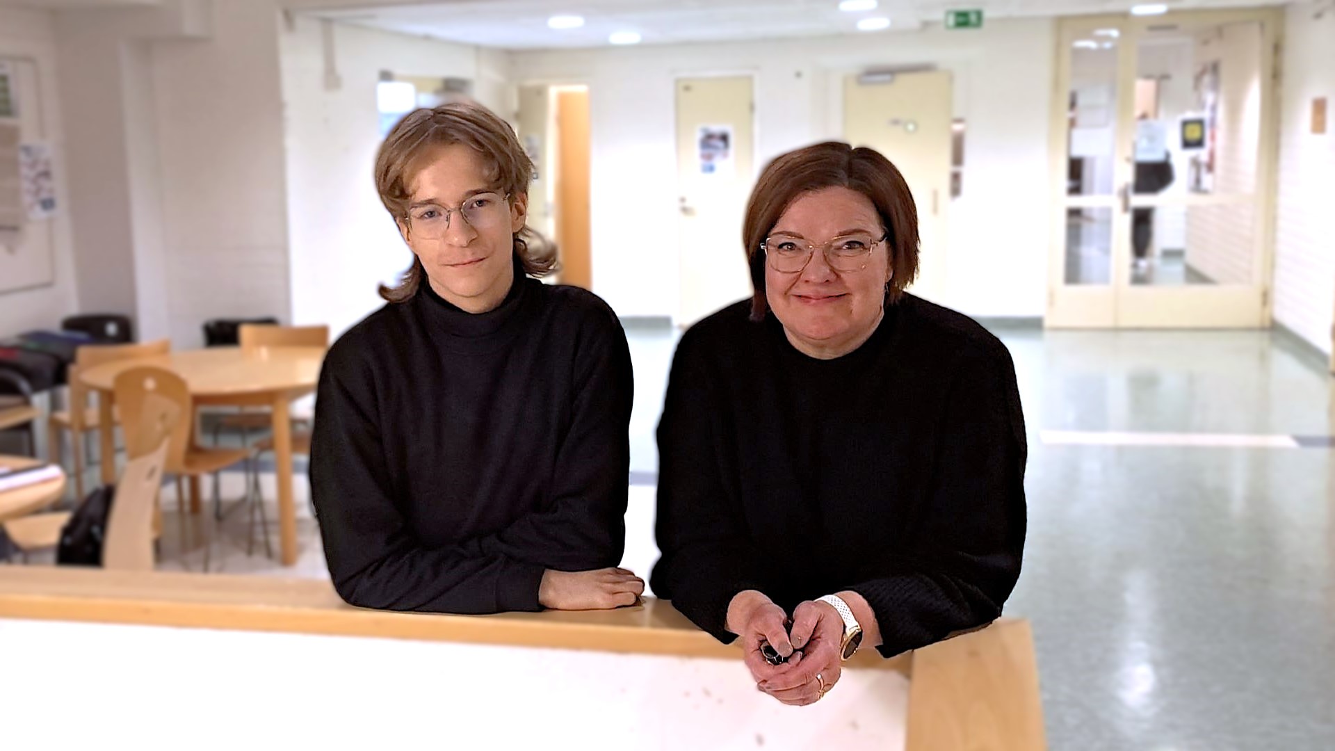 Topi Rokkonen ja helena puukka nojaavat porraskaiteeseen ja katsovat hymyillen suoraan kameraan.