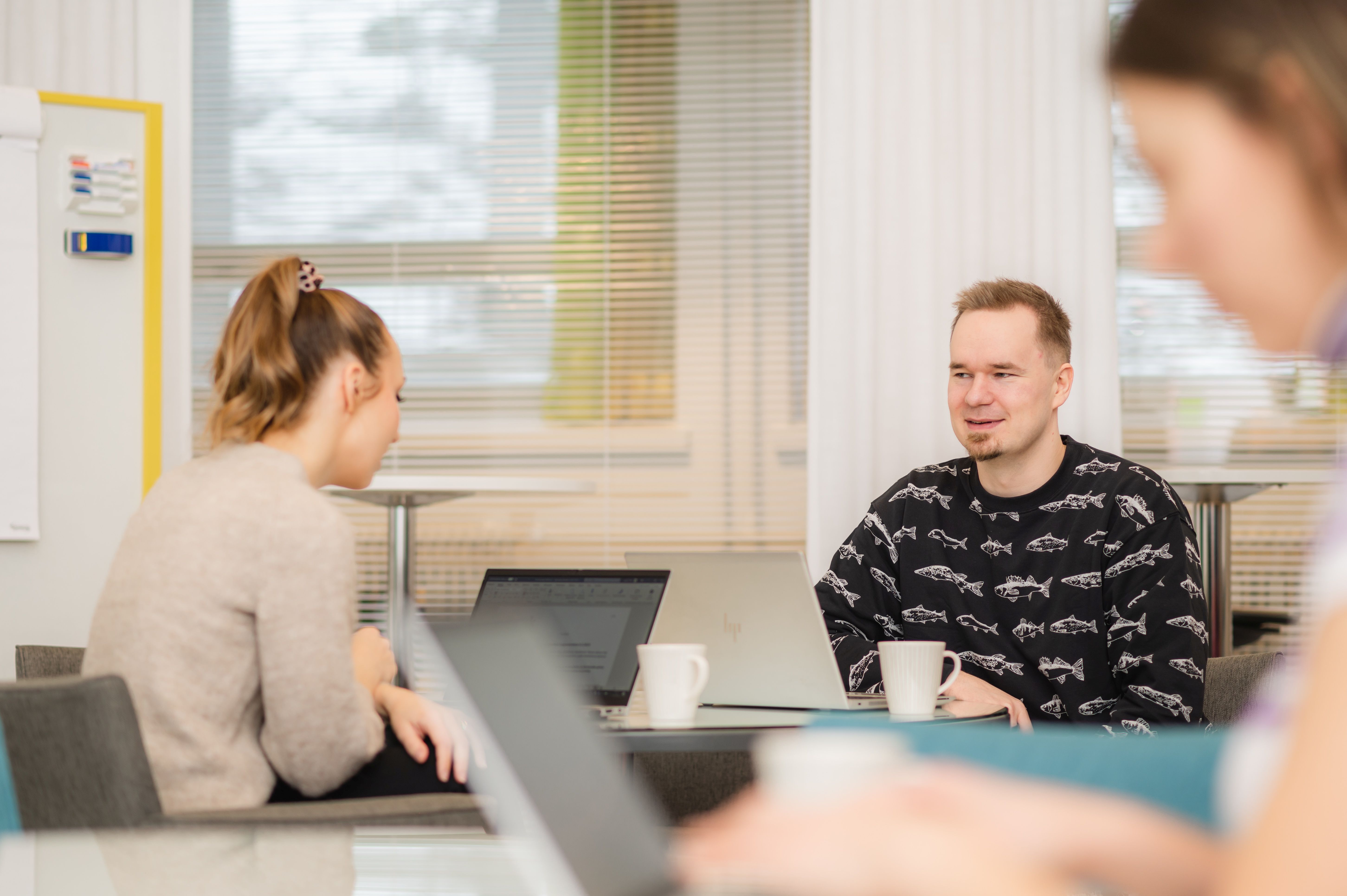 Pyödän äärellä istumassa ihmisiä kannettaviensa kanssa.