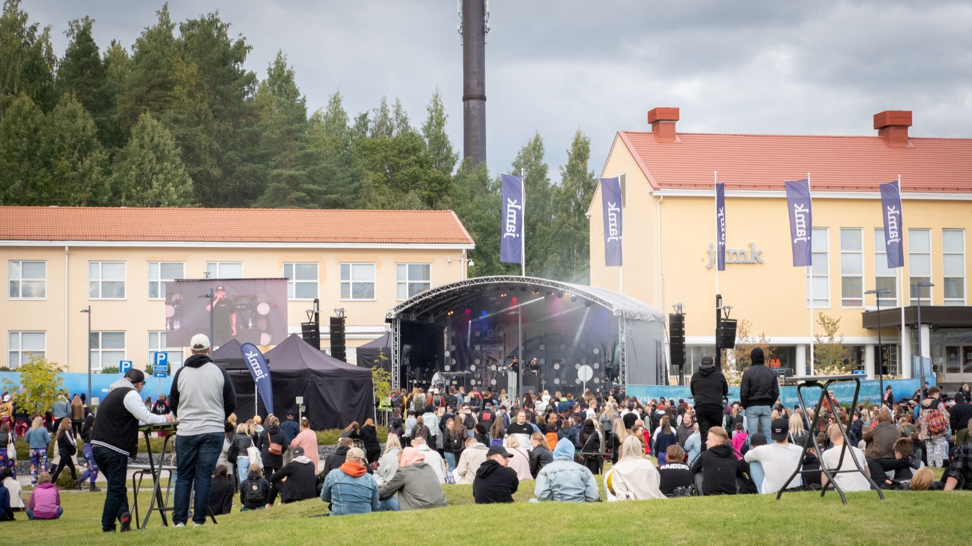 Runsaasti opiskeljoita istuu ja seisoo Jamkin pääkampuksen pihalla ja katselee lavalla olevaa esiintyjää.