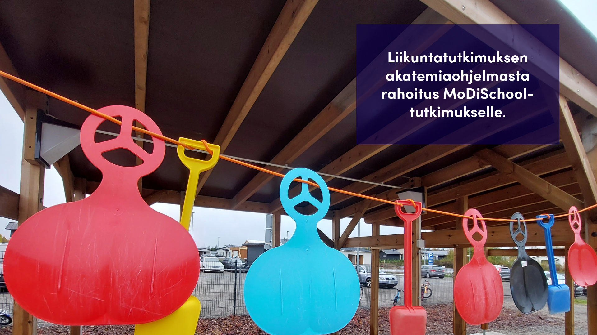 Leikkivälineitä roikkumassa telineestä.