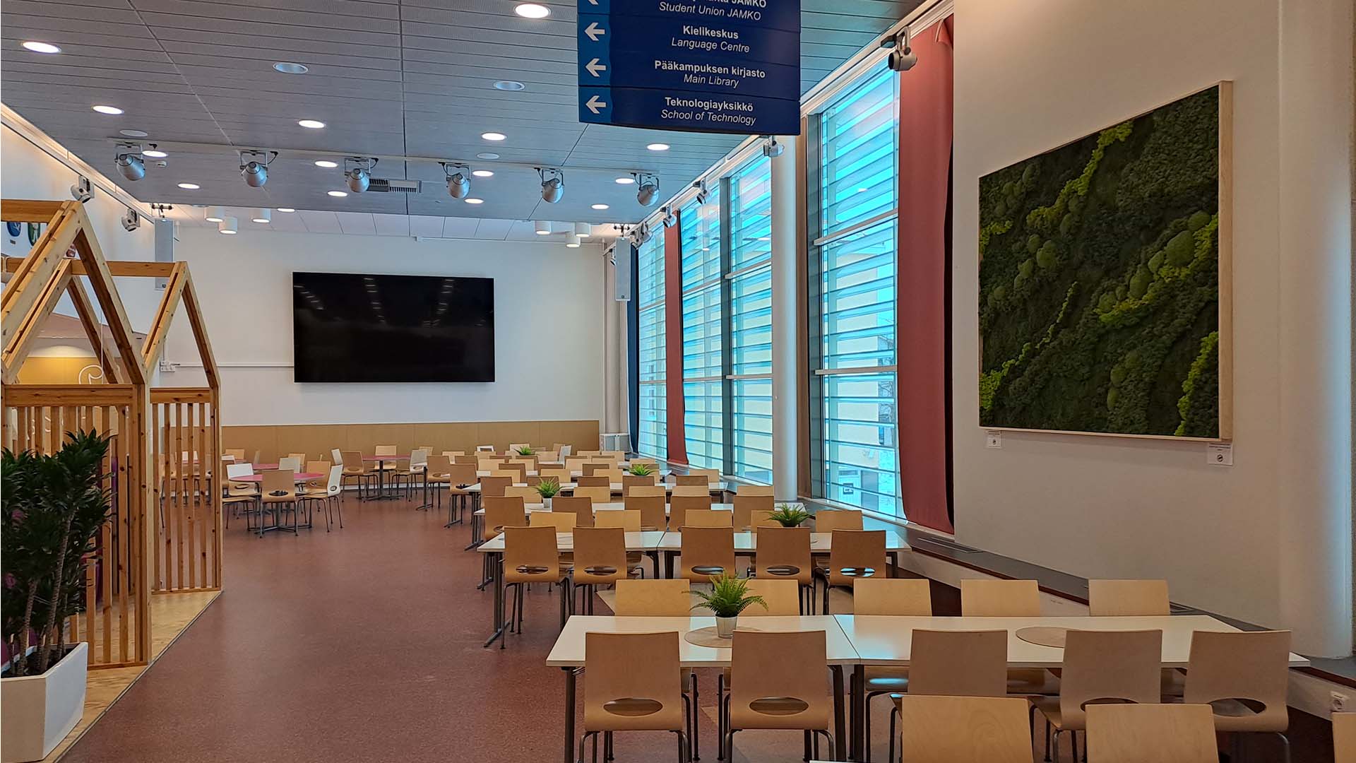 Big windows, wooden chairs and tables, screen on the back