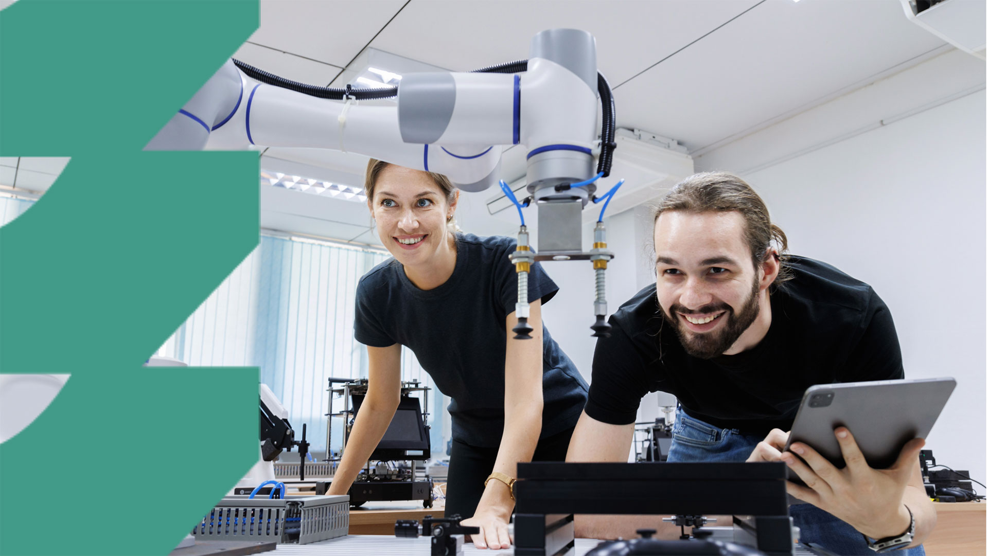 Nainen ja mies työskentelevät robotin parissa. Kuvan reunassa graafinen vihreä kuvio.