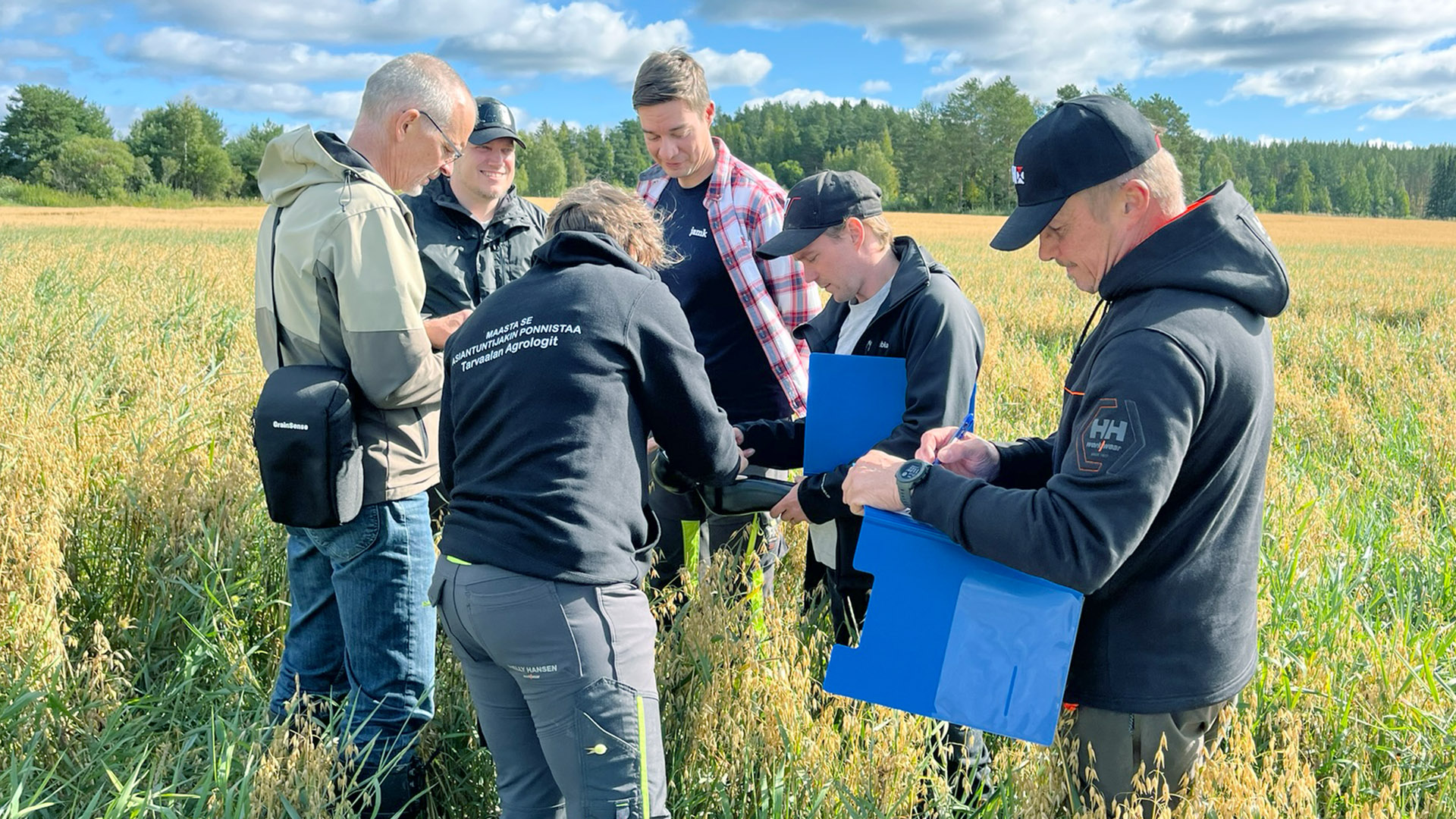 Ihmisiä maatilan pellolla