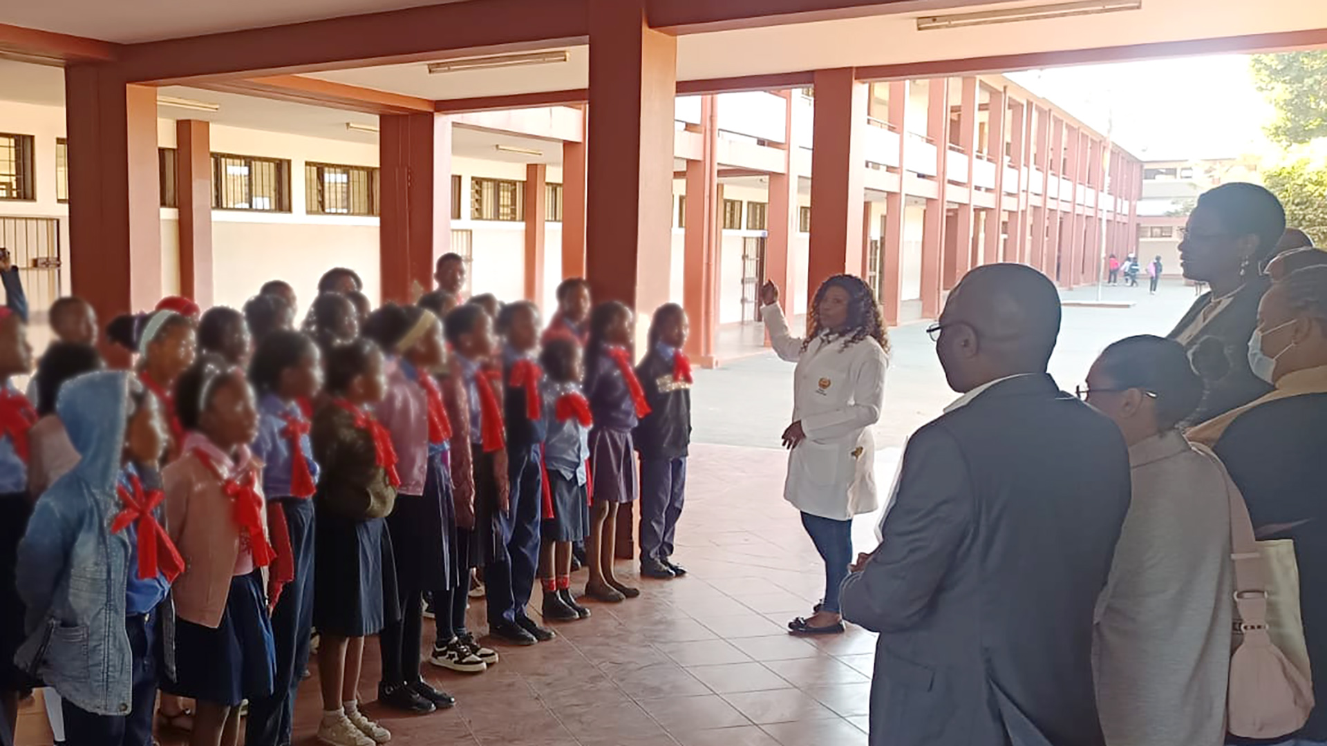 A teacher leads the singing of a children's class.