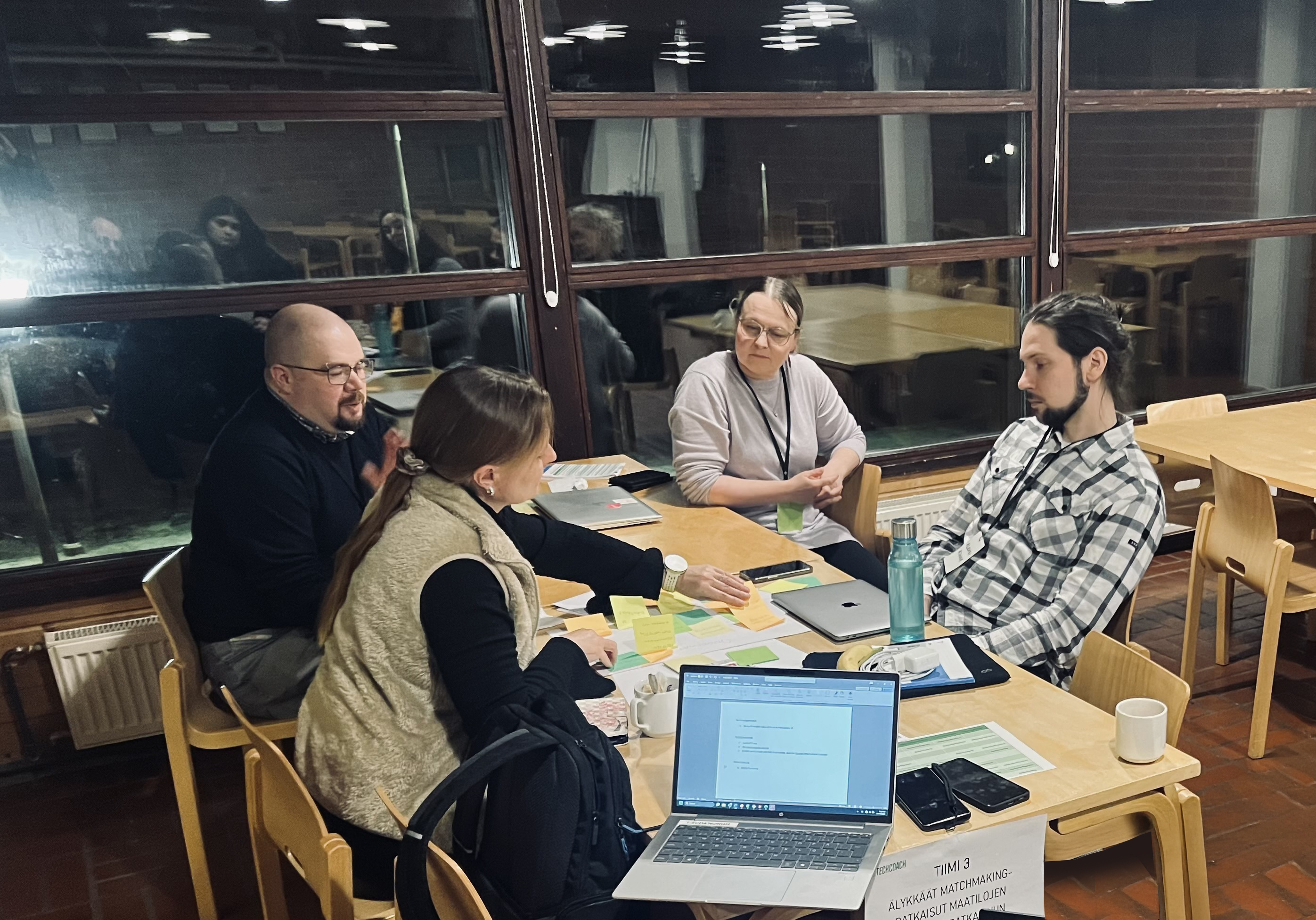 Ihmisiä pöydän ääressä keskustelemassa