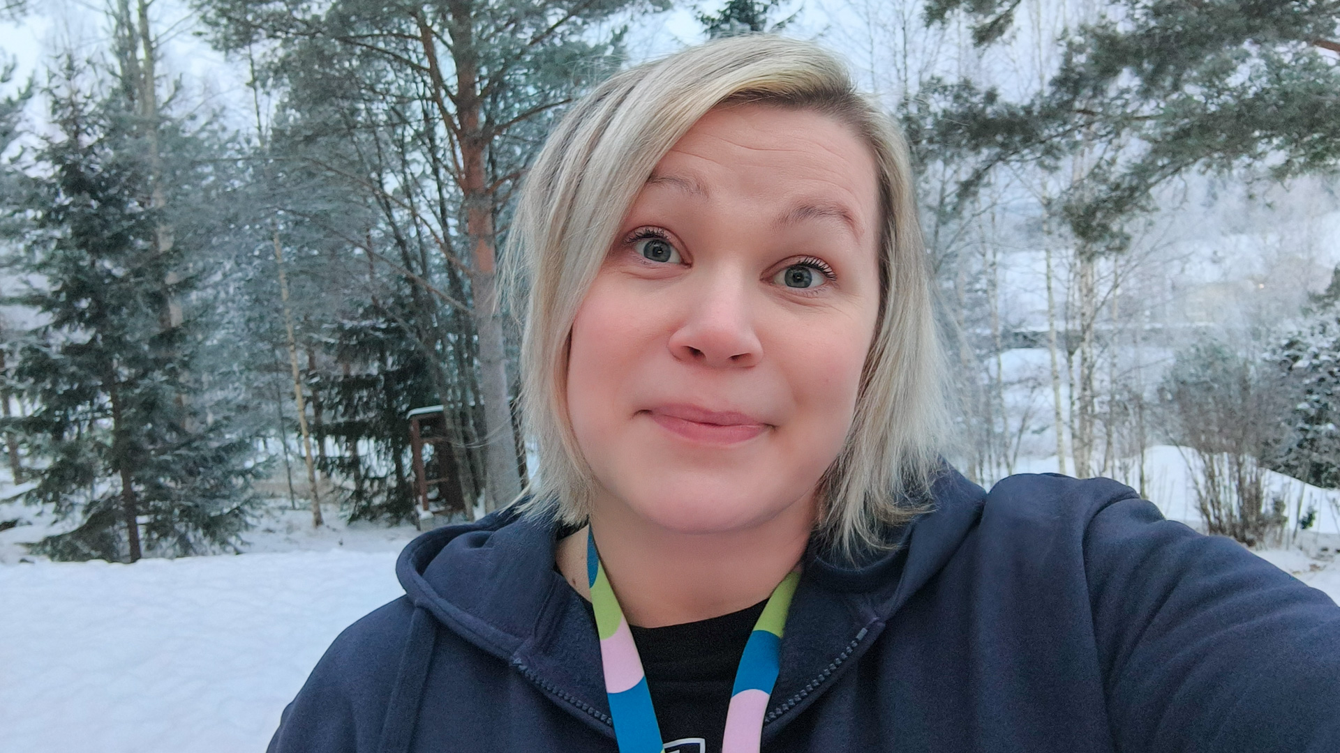 Marja Airola katsoo hymyillen kameraan. Taustalla näkyy talvinen maisema.