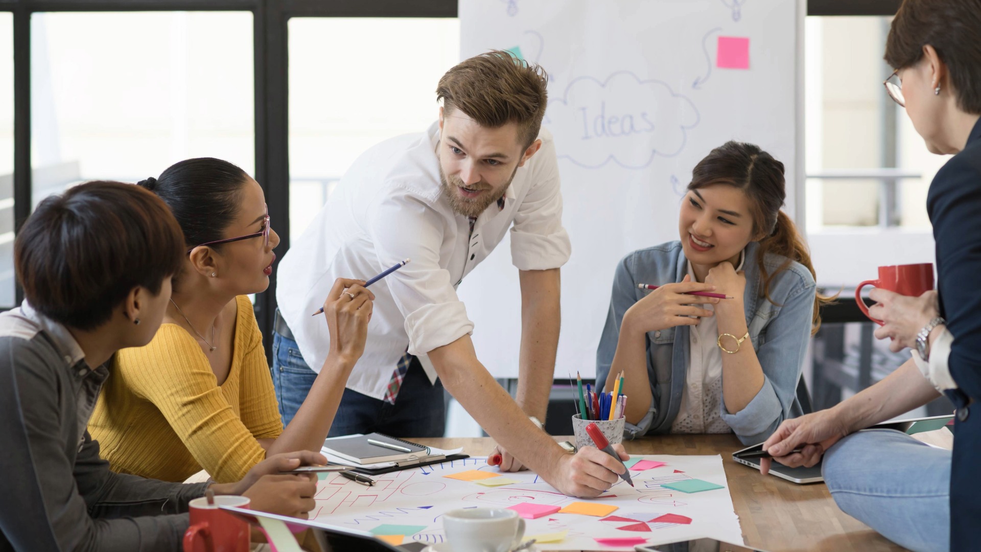 Henkilöitä työskentelemässä yhdessä pöydän ääressä.