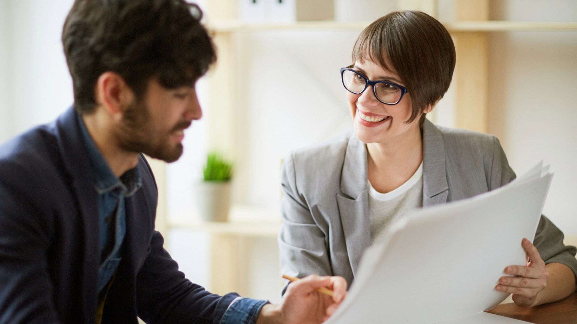 Nainen ja mies keskustelevat tietokoneen äärellä