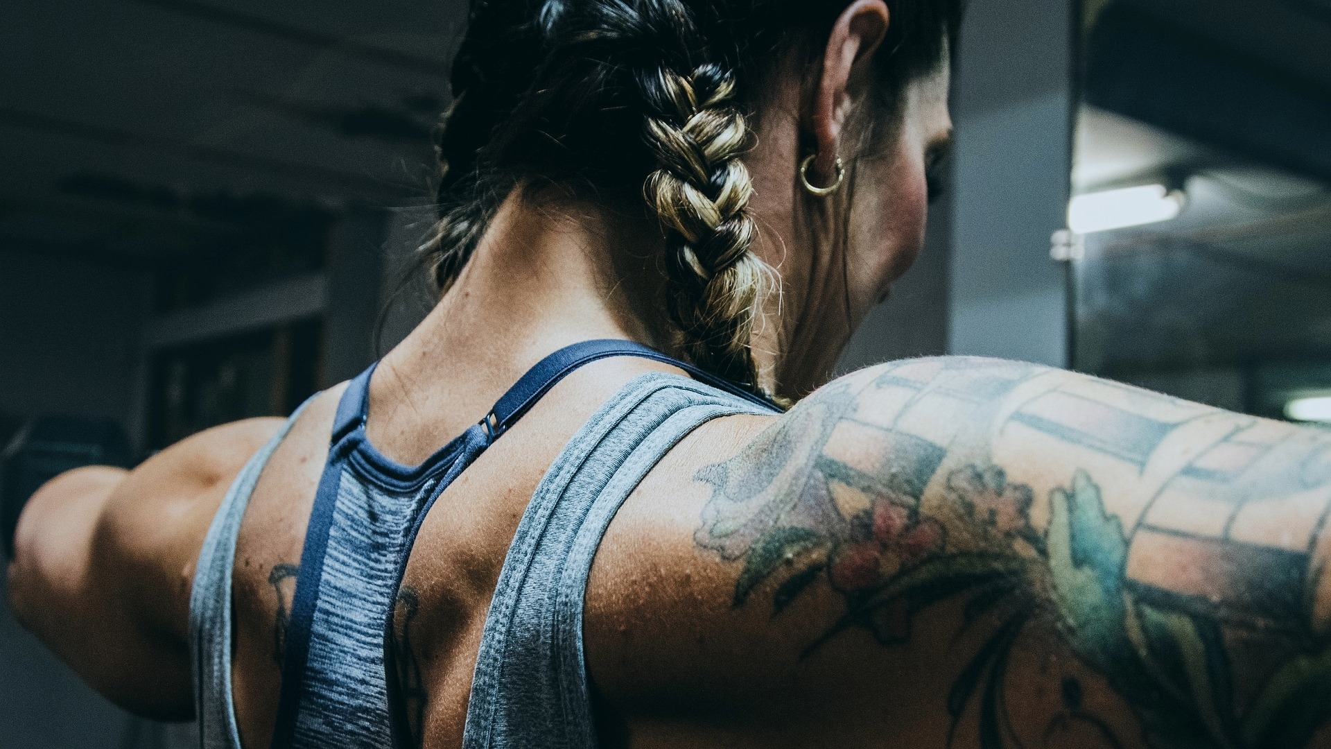 lähikuva naisen olkapäästä, lihakset ja tatuoinnit