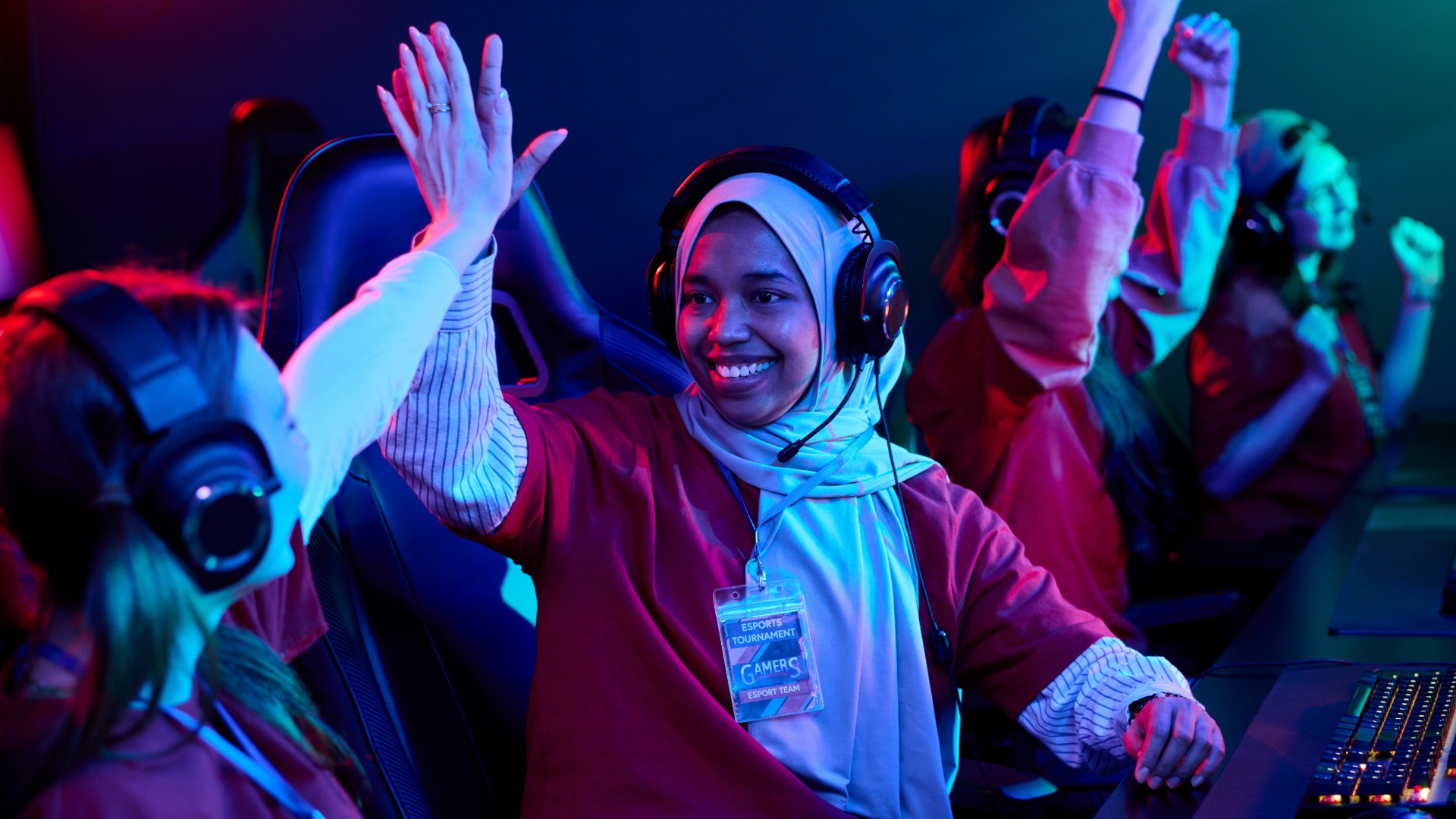 People playing computer games and giving eachother a fighfive.