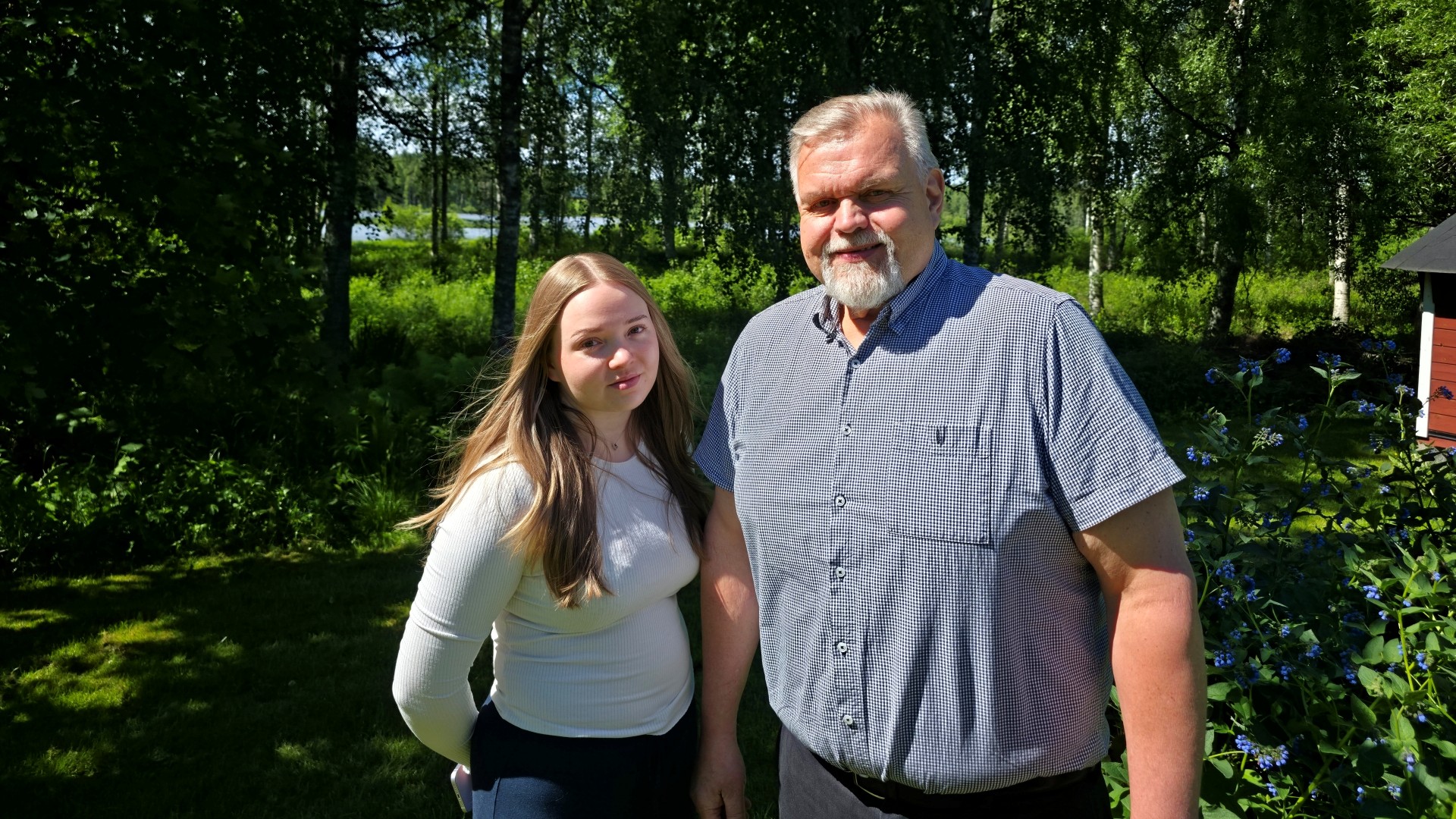 Sani ja Jari Pasanen seisovat aurinkoisessa, kesäisessä maisemassa ja katsovat suoraan kameraan.