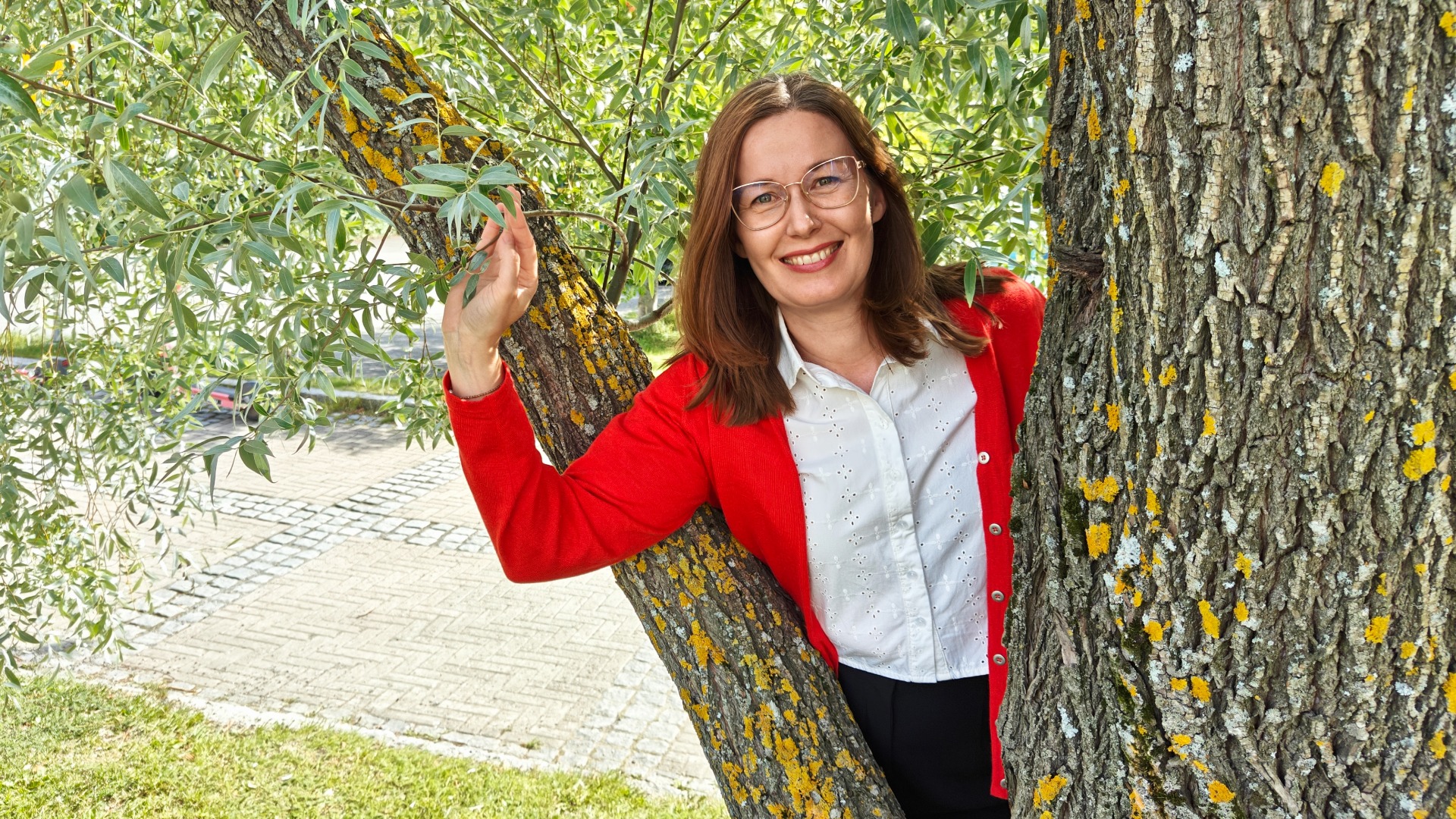 Eeva Aartolahti hymyilevä nainen punainen neuletakki