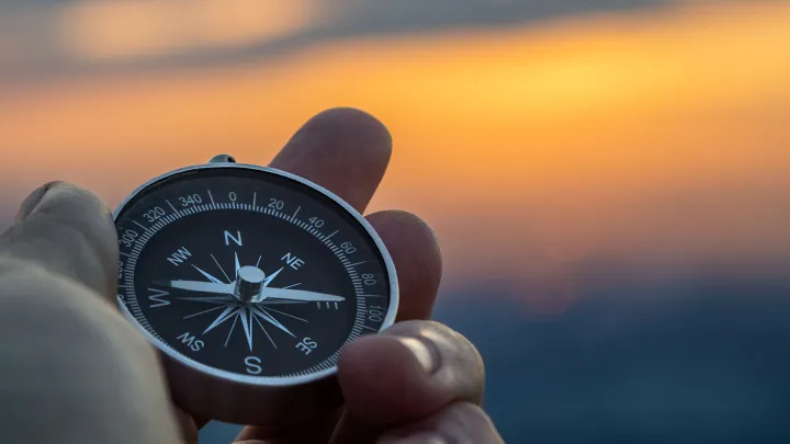 Hand holding a compass