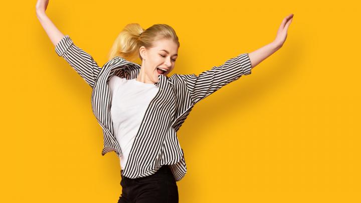 Happy female student on a yellow background